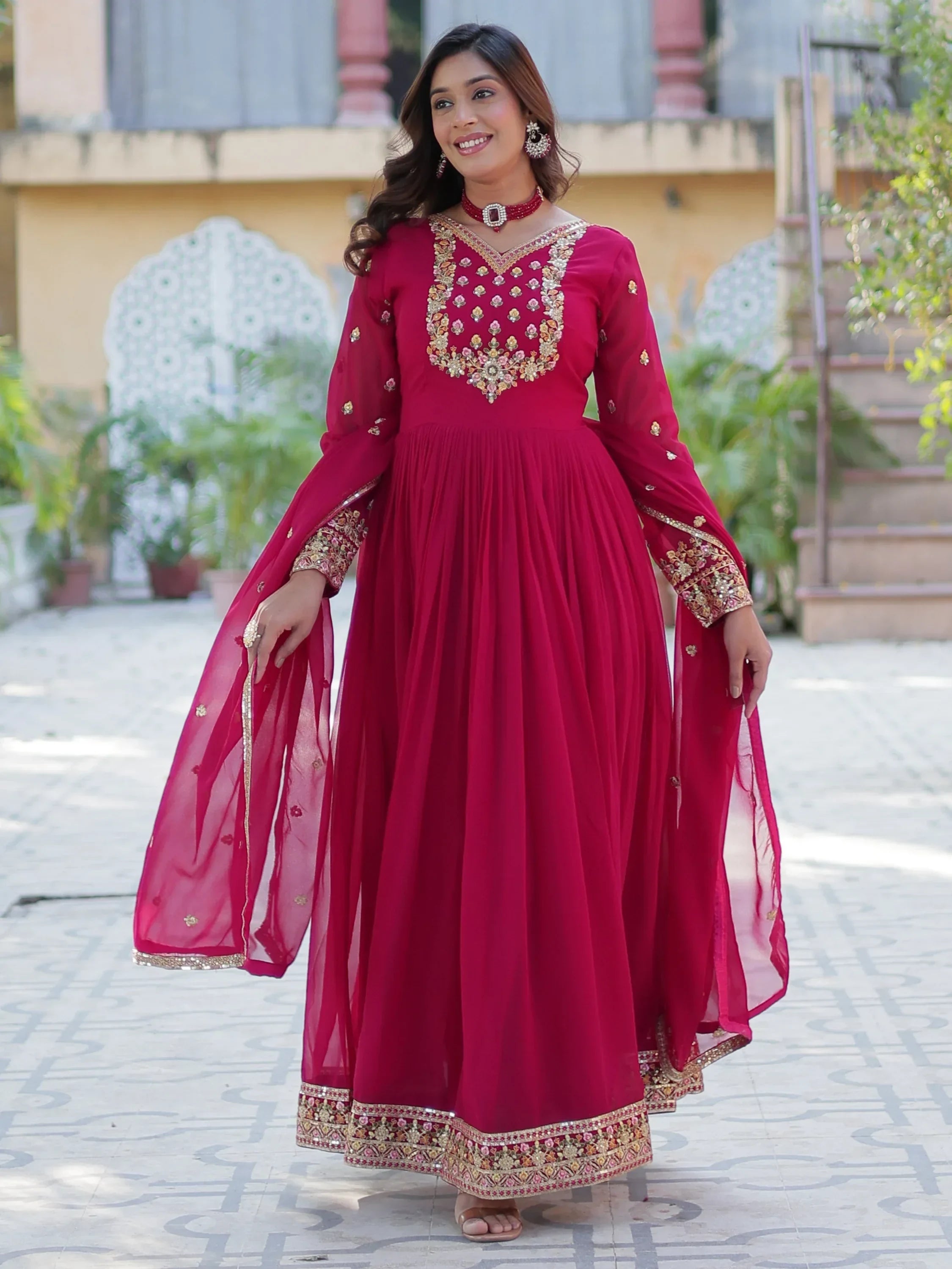 Woman in pink embroidered Anarkali gown with gold detailing, ethnic Indian festive wear