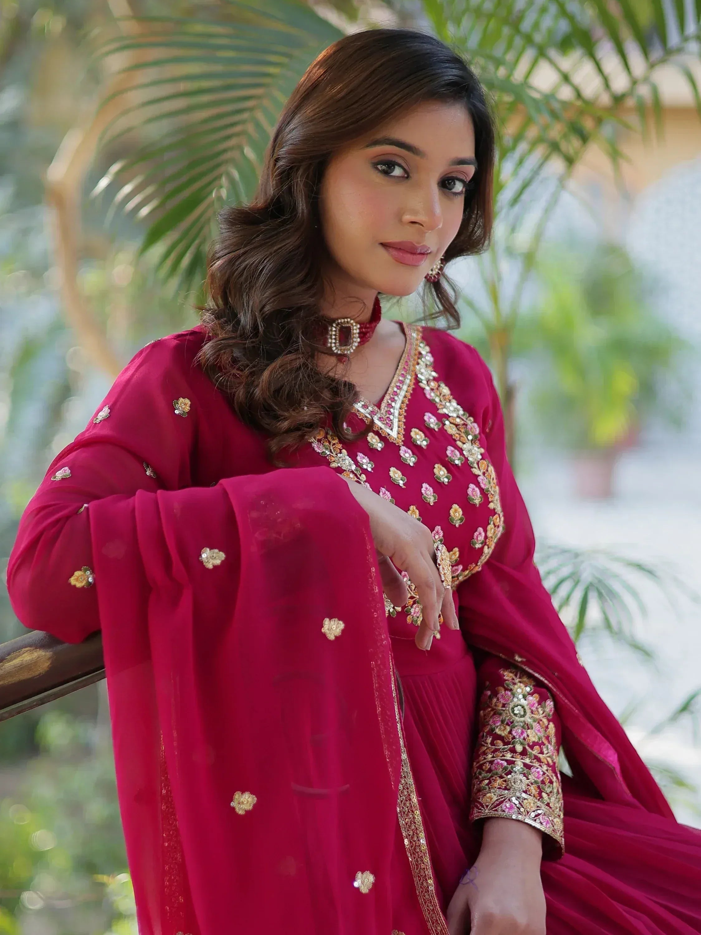 Woman in maroon embroidered salwar kameez with floral detailing, perfect for Indian ethnic wear occasions
