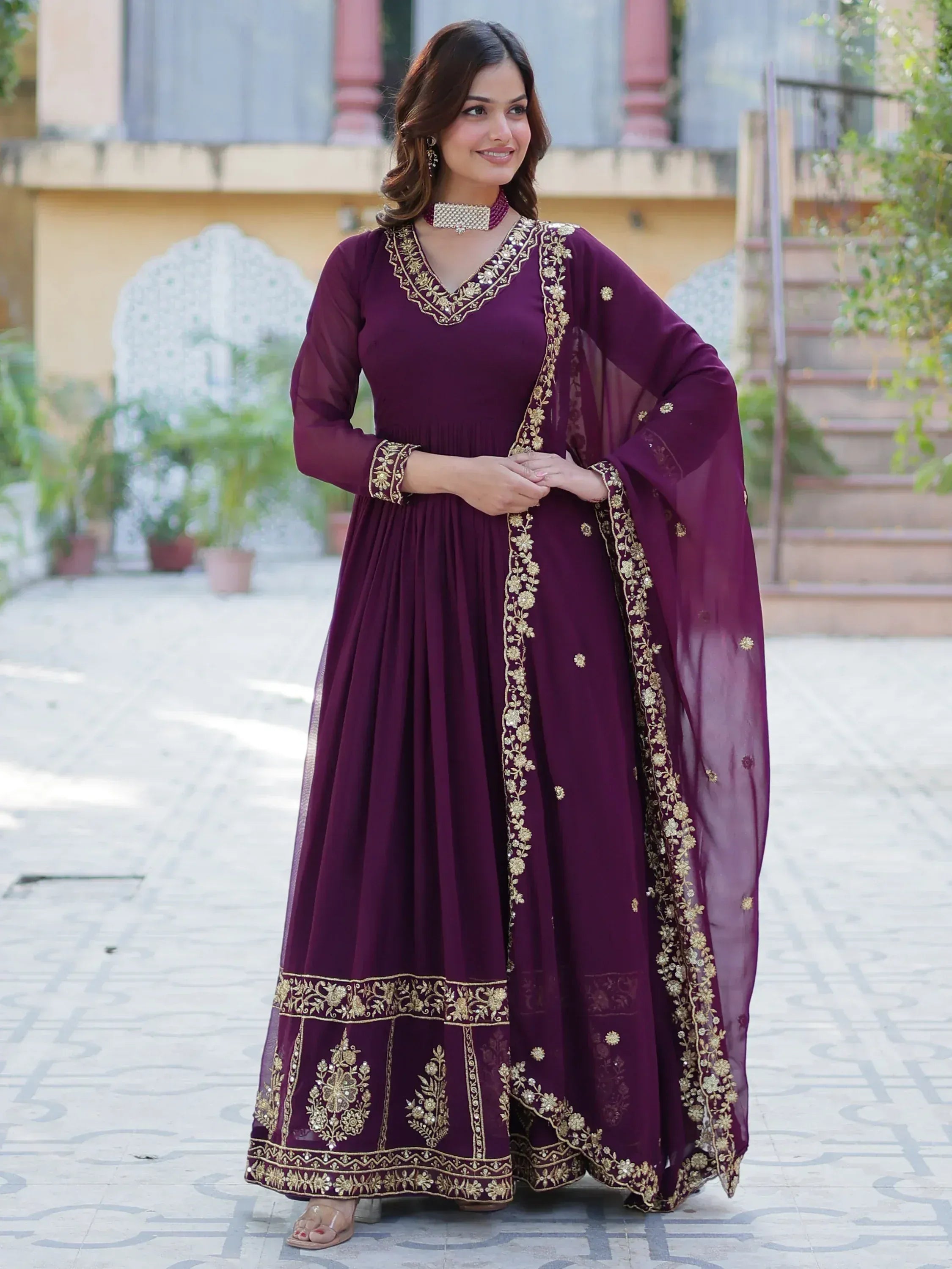 Elegant maroon ethnic gown with gold embroidery, perfect for Indian celebrations and events.