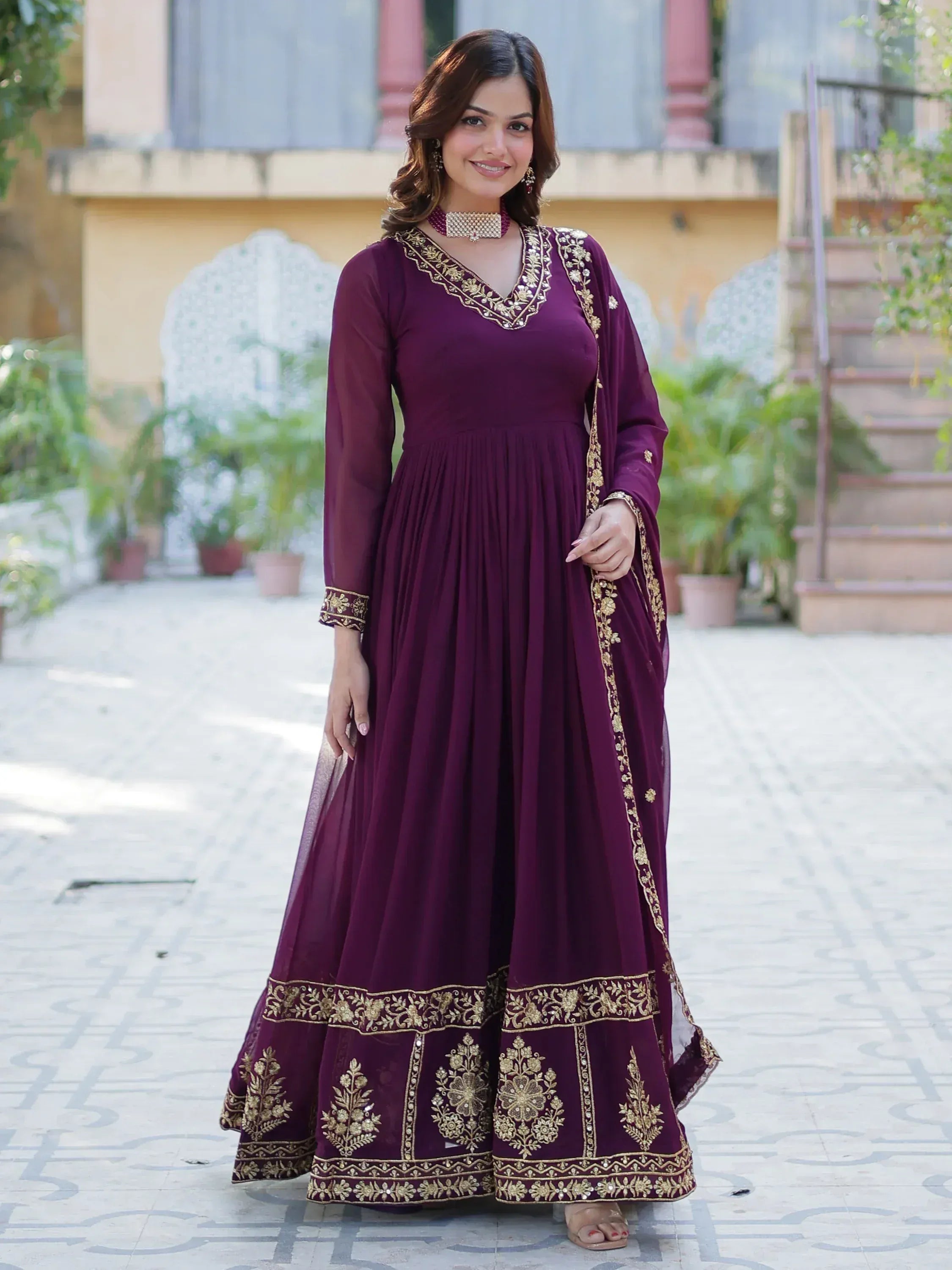 Elegant maroon ethnic gown with gold embroidery, perfect for Indian festive occasions.