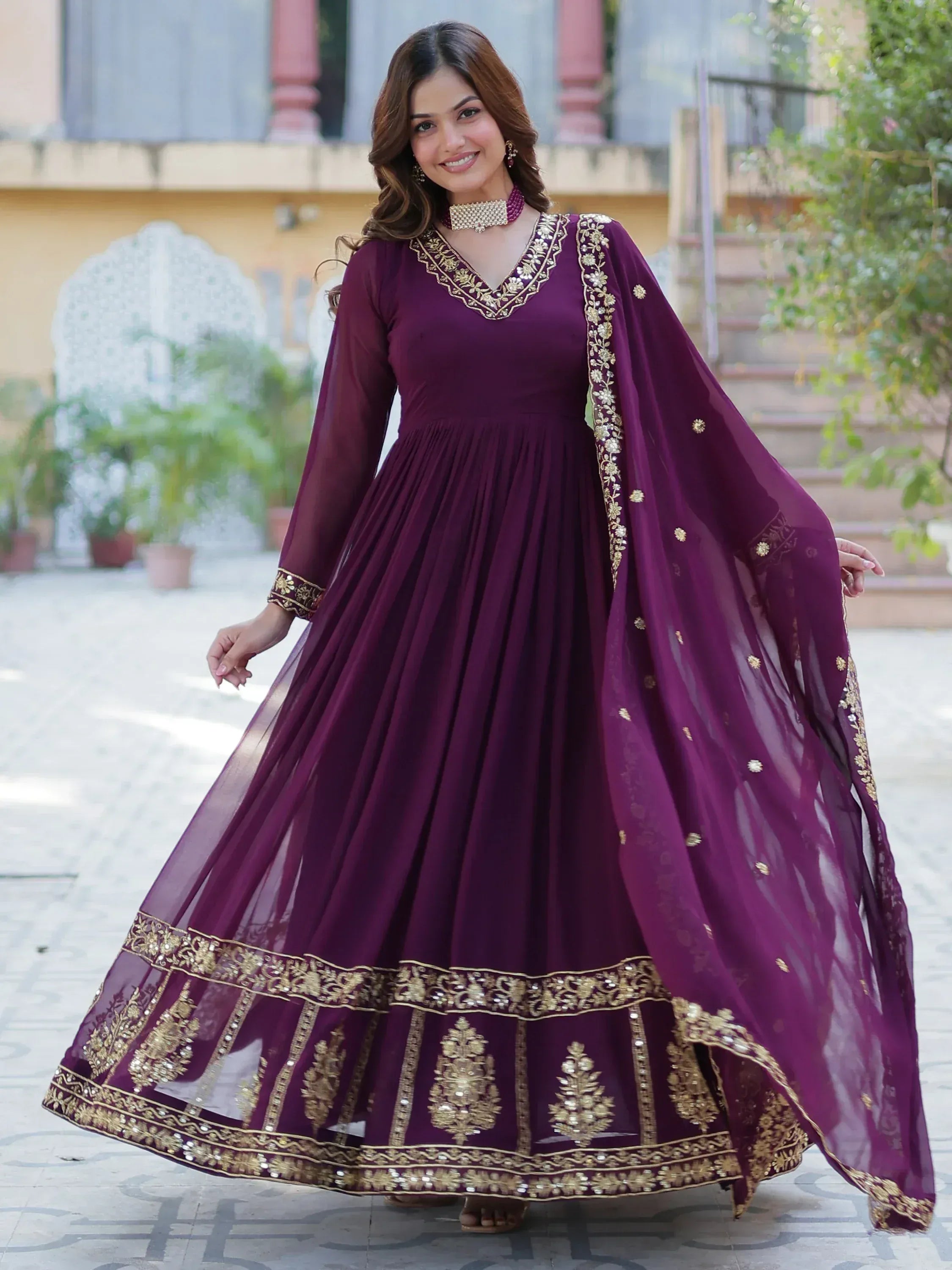 Elegant purple ethnic gown with gold embroidery, perfect for Indian celebrations and festive occasions.