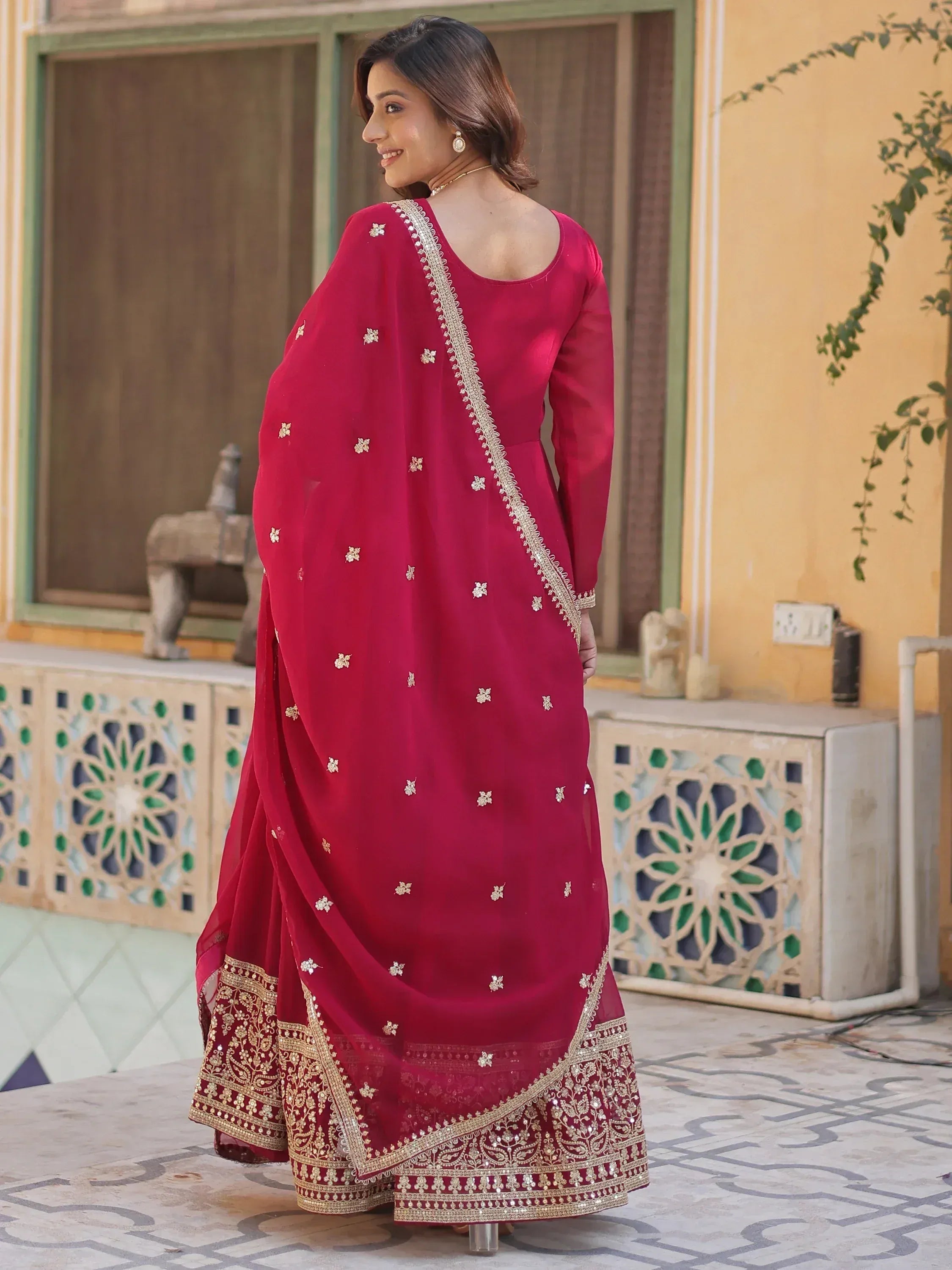 Woman in maroon ethnic anarkali with gold embroidery and dupatta, traditional Indian wear