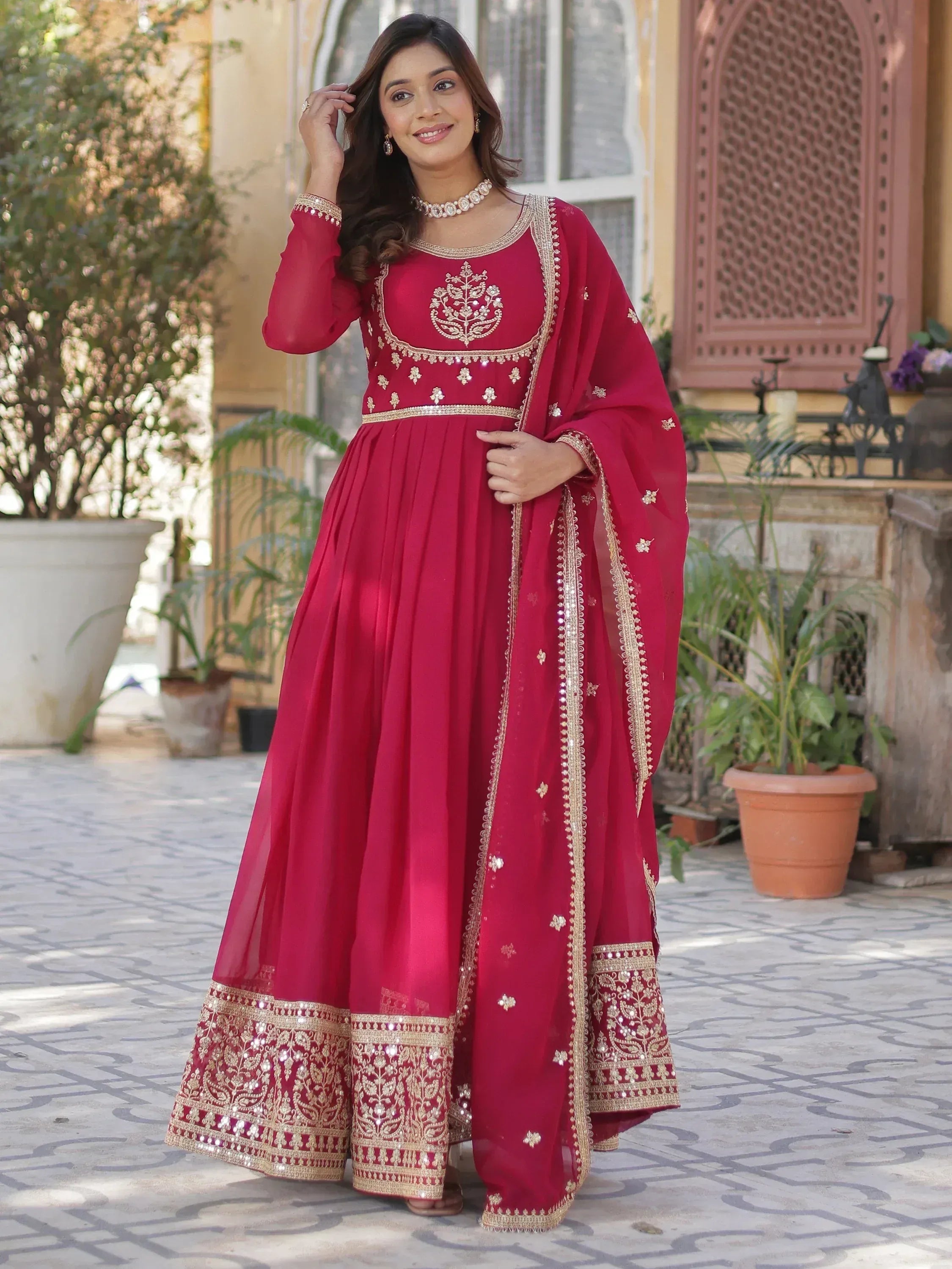Elegant maroon ethnic gown with gold embroidery, perfect for Indian celebrations and festive occasions.
