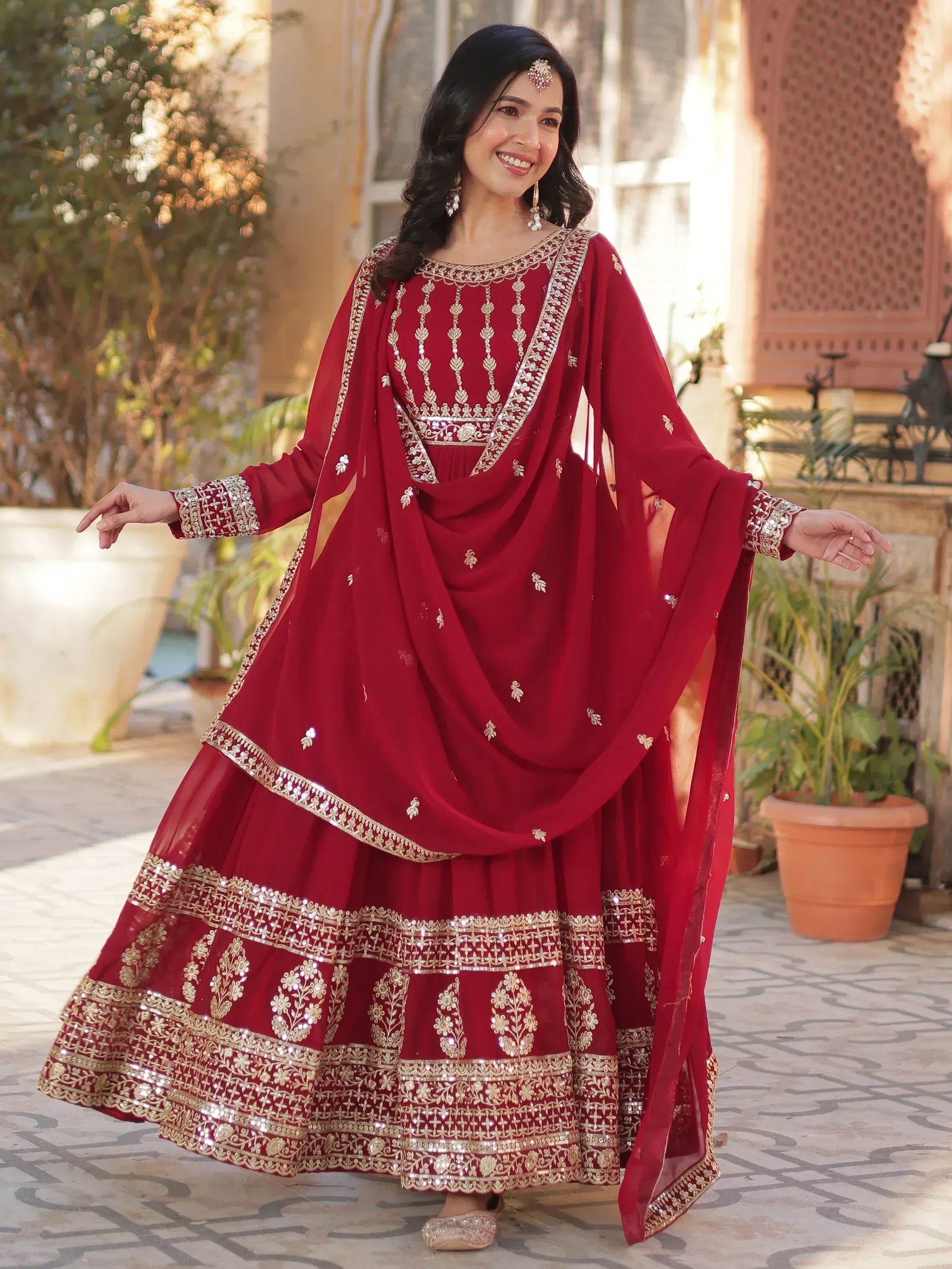 Woman in maroon embroidered Indian ethnic wear with gold detailing, perfect for weddings and festivals