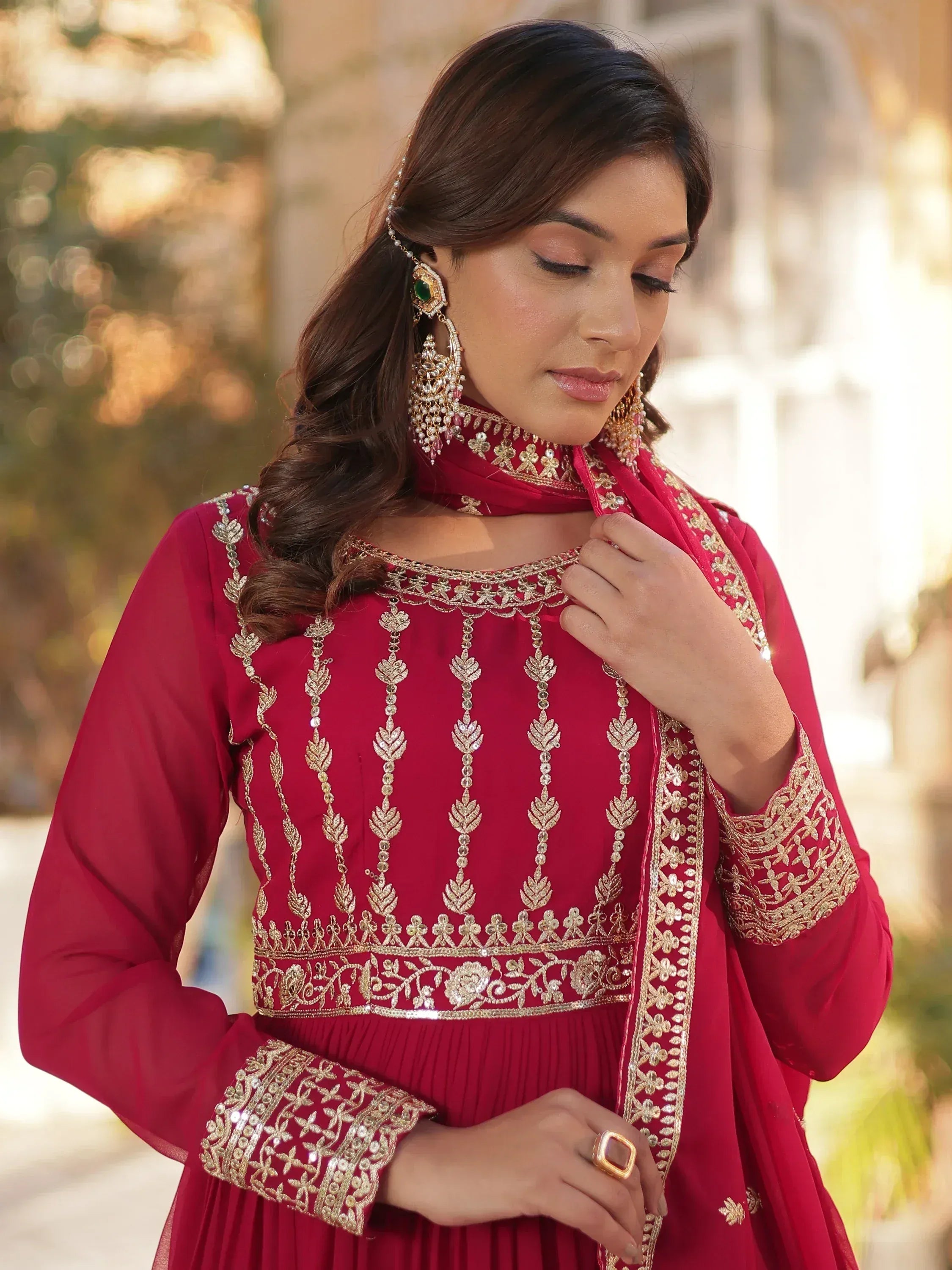 Elegant maroon ethnic gown with gold embroidery, perfect for Indian weddings and festive occasions.