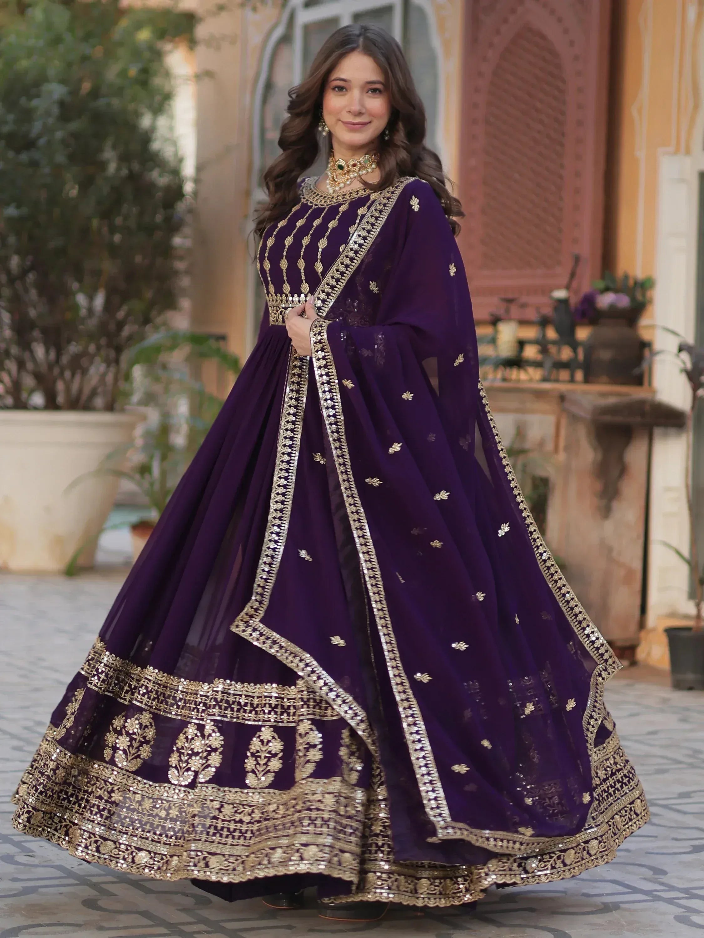 Elegant purple Indian ethnic gown with gold embroidery, perfect for weddings and festive occasions.
