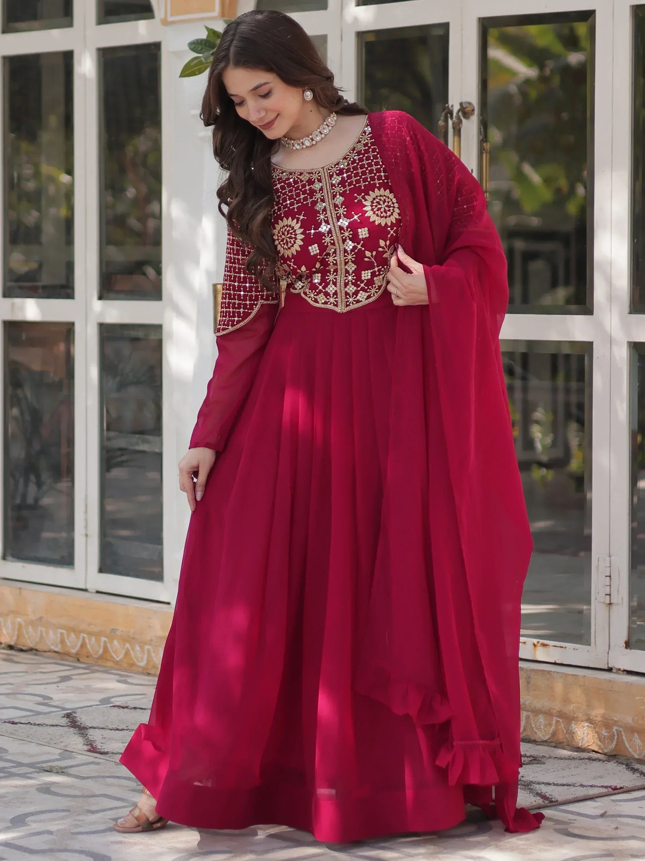 Maroon ethnic gown with gold embroidery, perfect for Indian weddings or festive occasions.