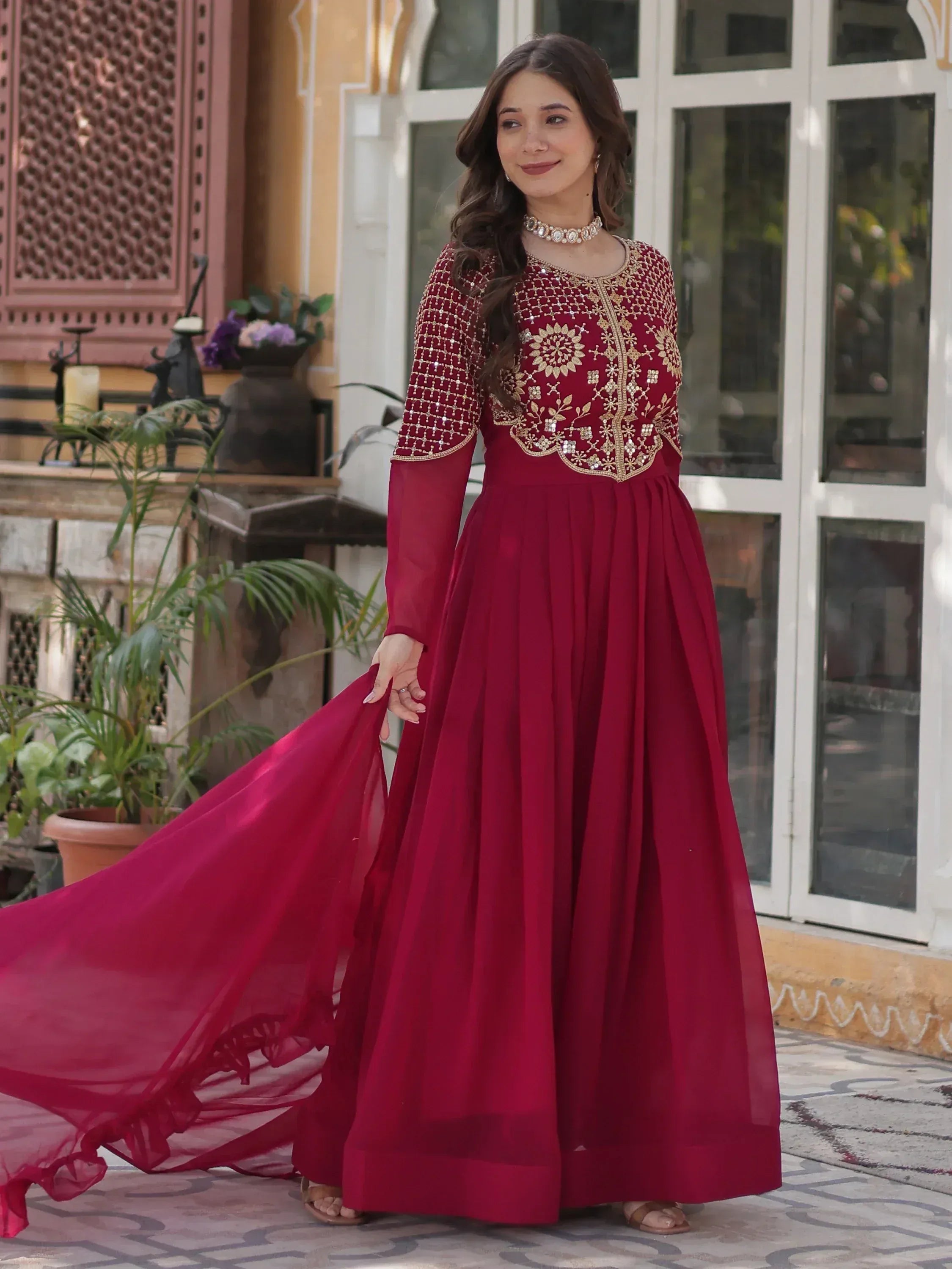 Elegant maroon ethnic gown with gold embroidery, perfect for Indian weddings and festive occasions.