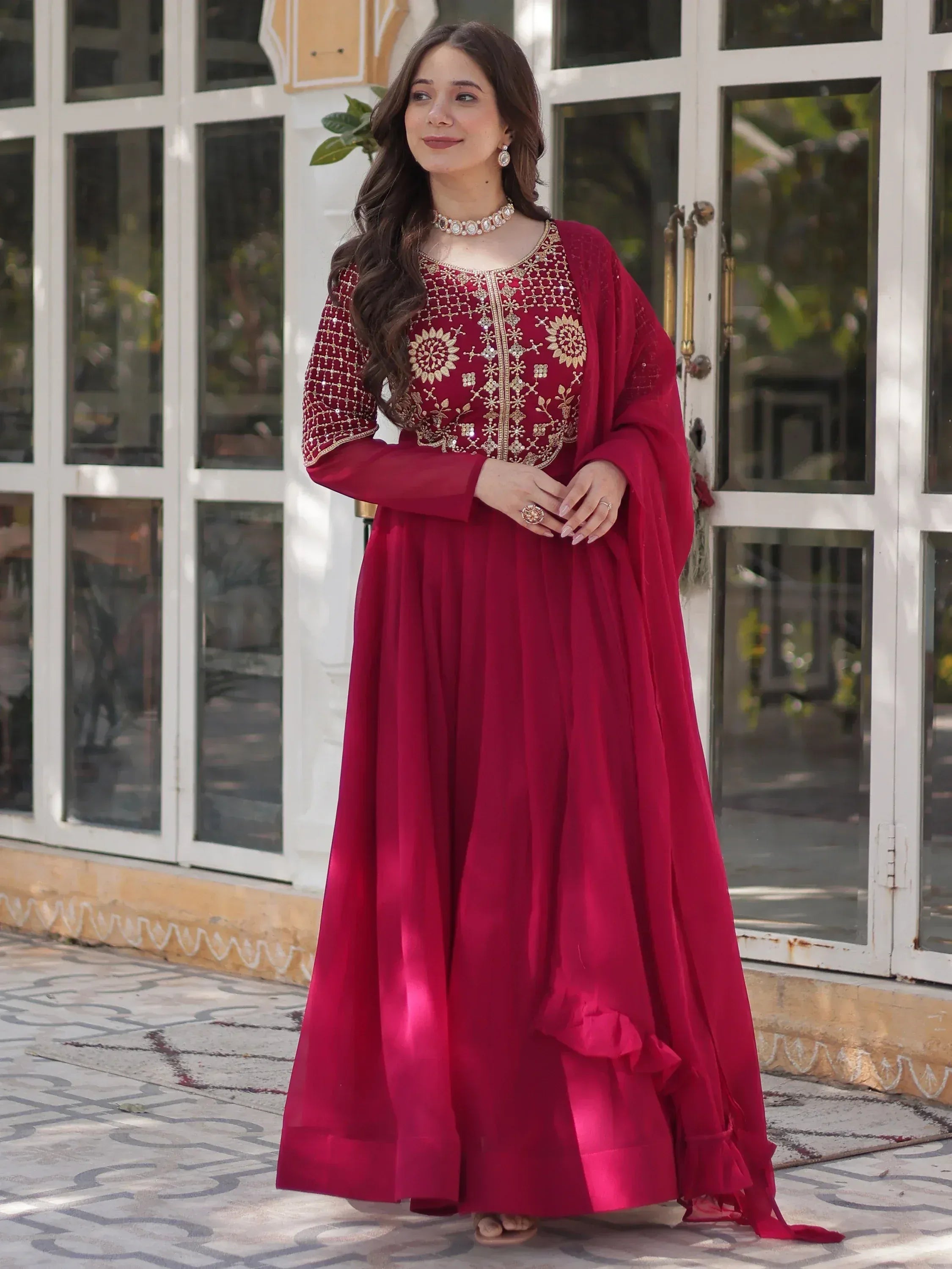 Elegant maroon ethnic gown with gold embroidery, perfect for Indian celebrations and festive occasions.