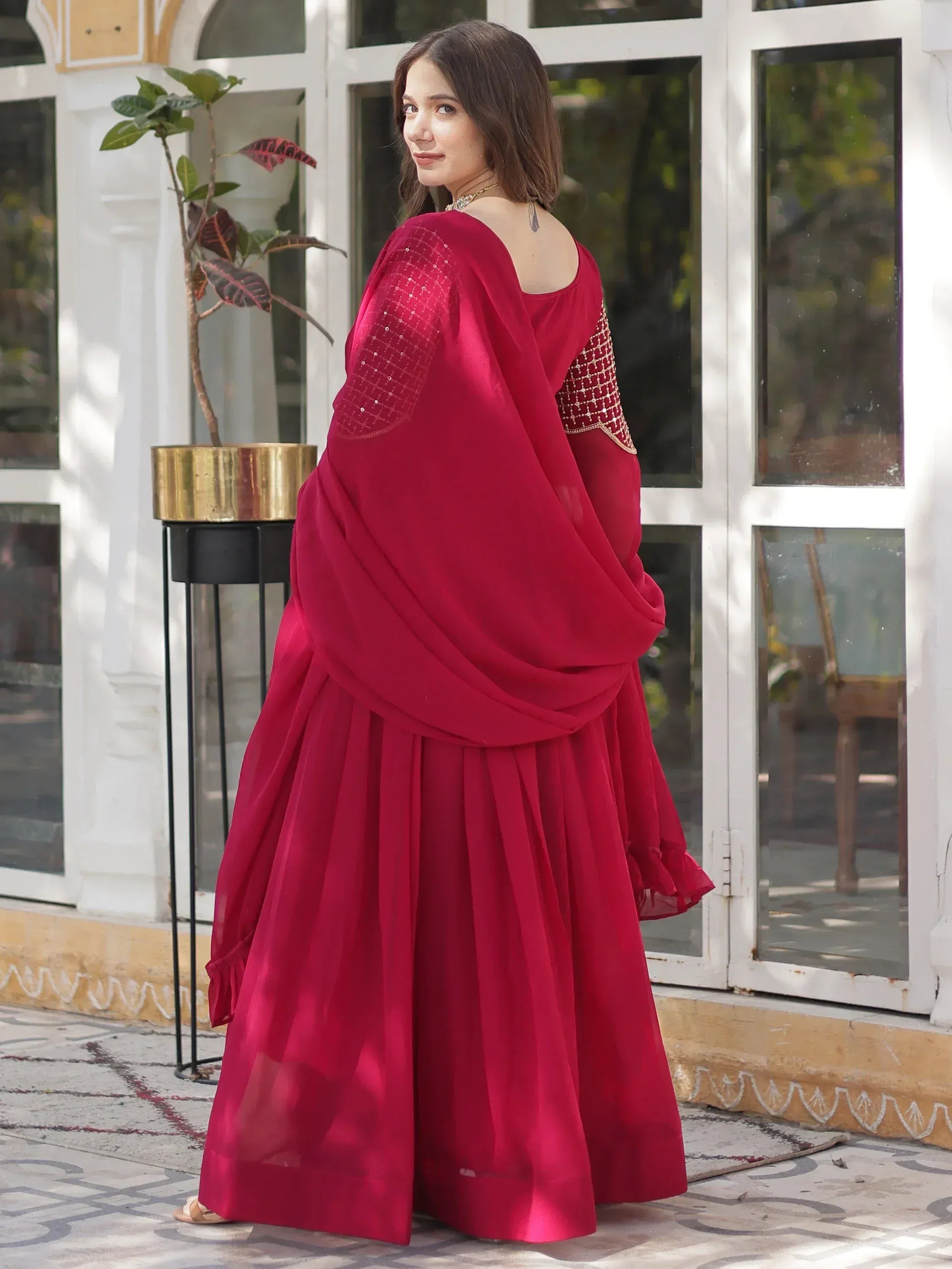 Red ethnic gown with sequin sleeves and pleated skirt, perfect for Indian occasions