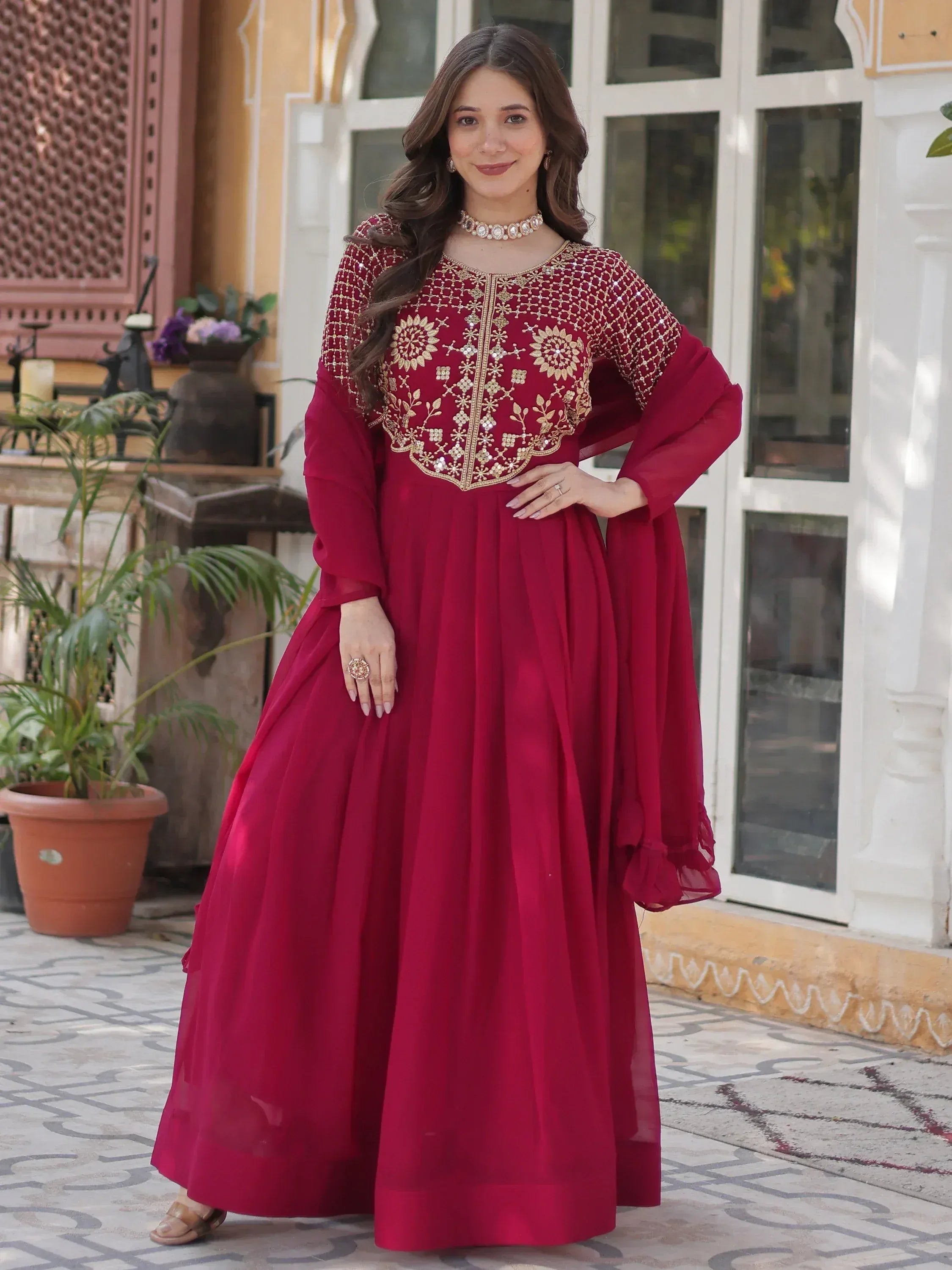 Elegant maroon ethnic gown with gold embroidery, perfect for Indian celebrations and festive occasions.