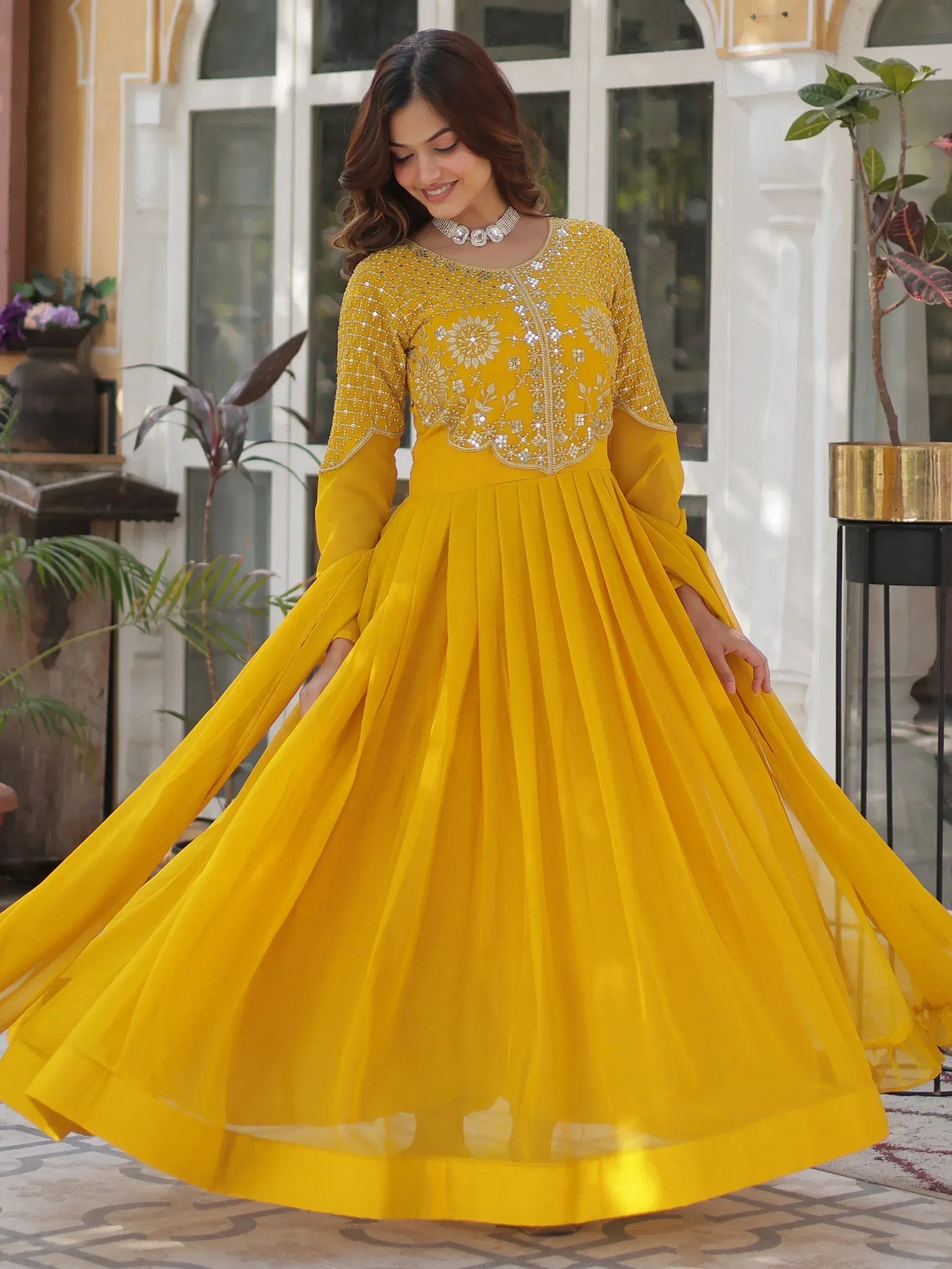 Yellow ethnic gown with floral embroidery and pleated skirt for festive occasions