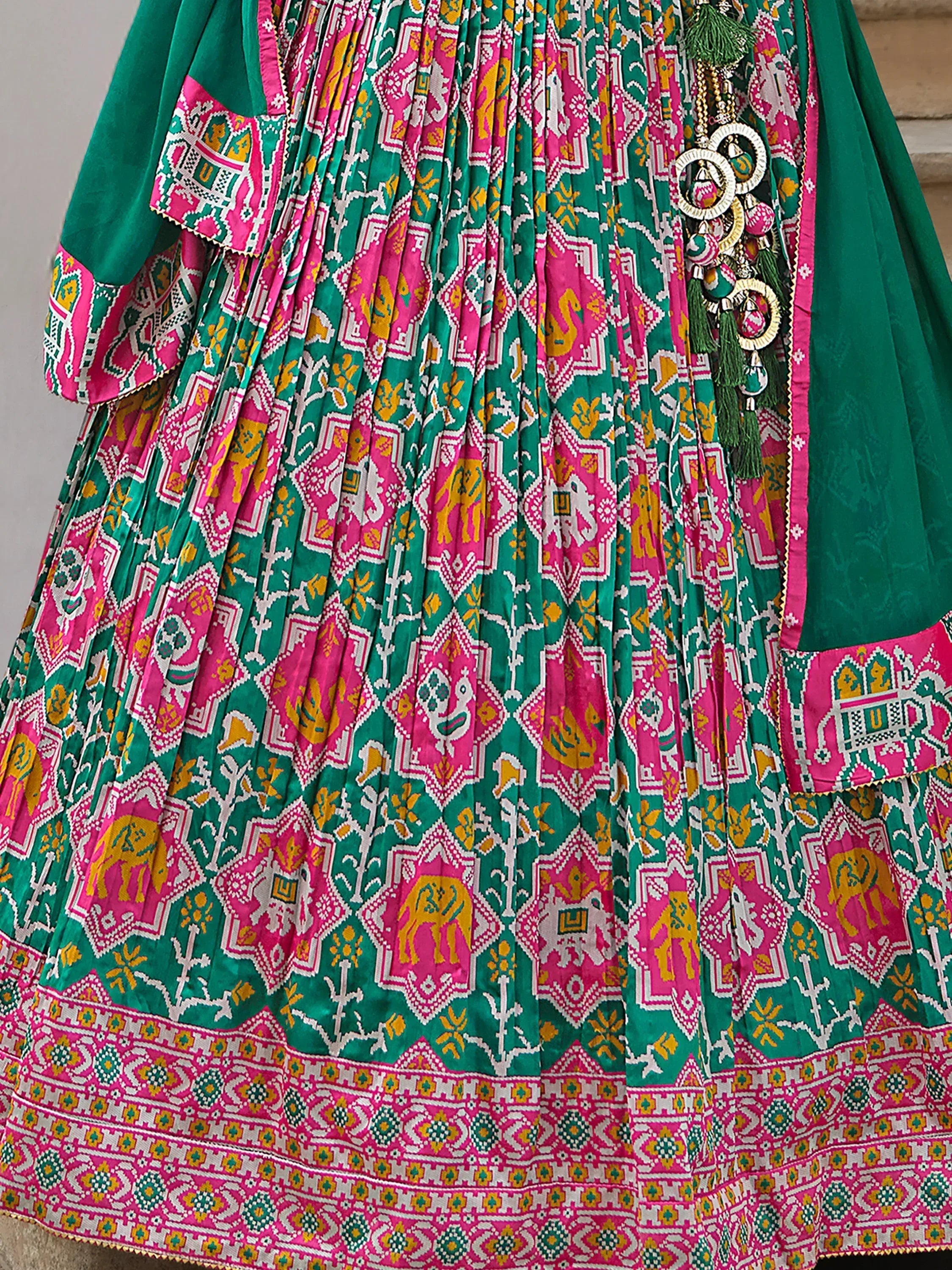 Vibrant green and pink printed lehenga choli with elephant motifs and tassel details, ethnic Indian wear
