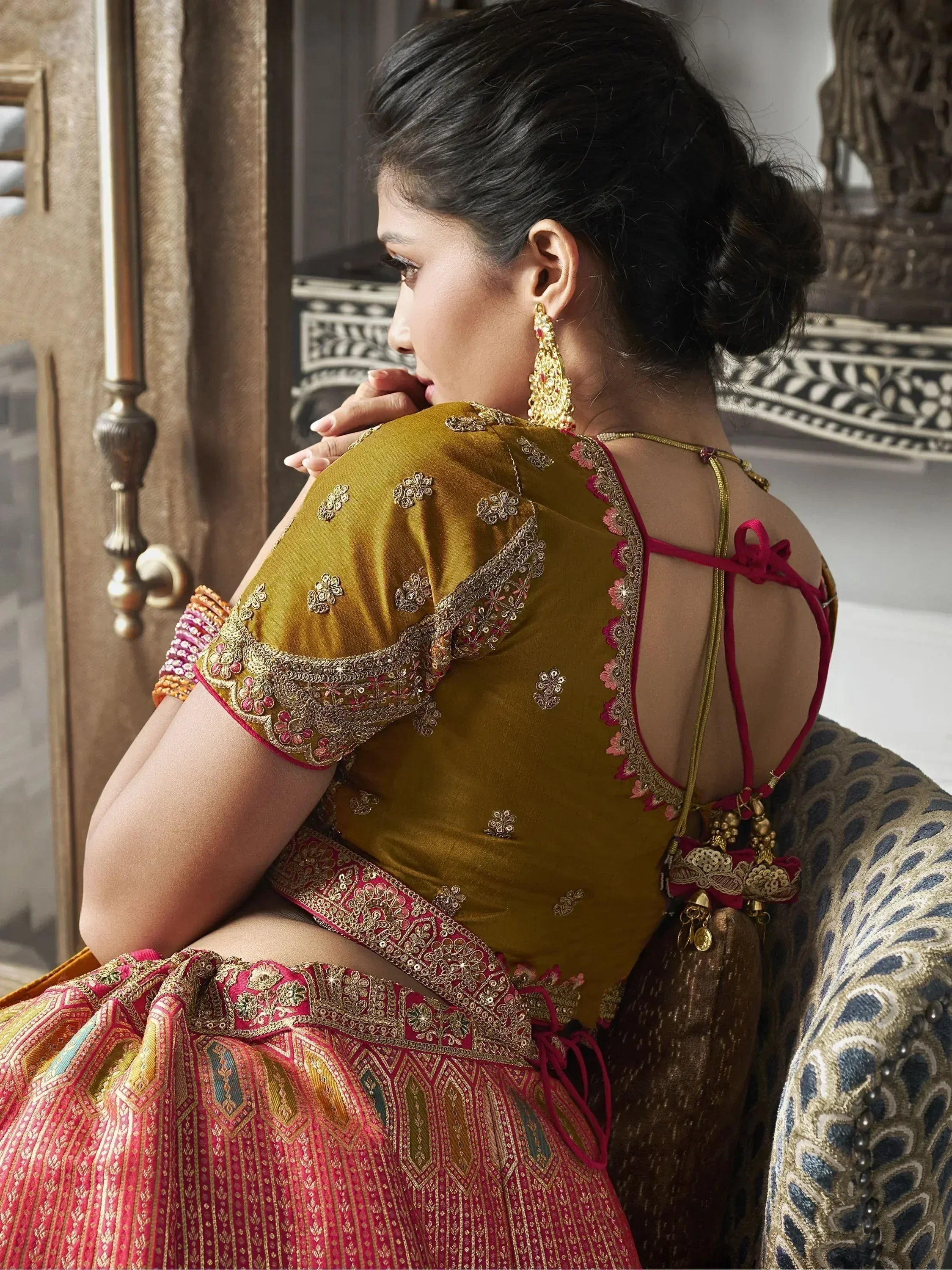 Elegant Indian ethnic lehenga choli with gold embroidery, backless blouse, and traditional jewelry