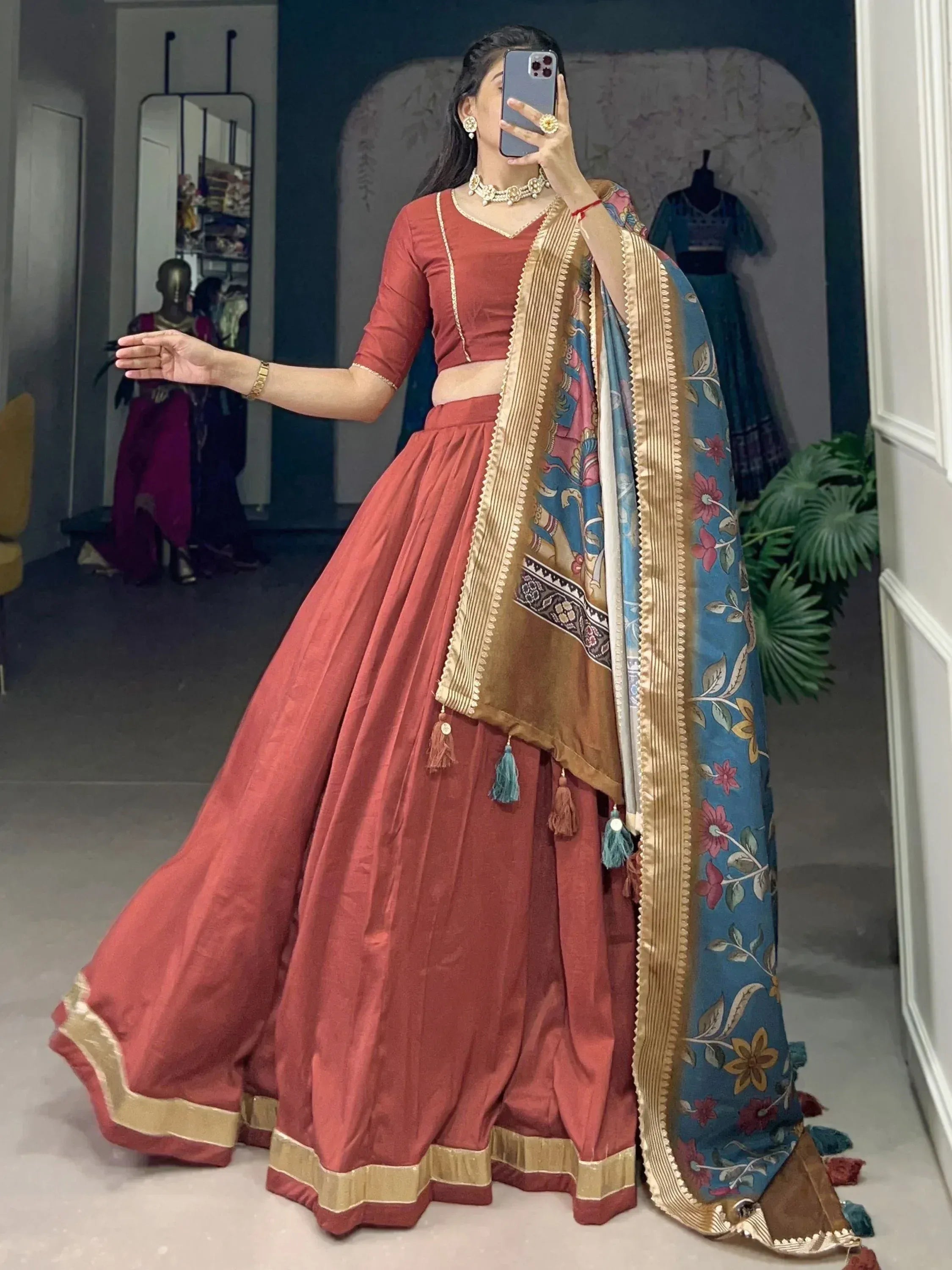 Woman in coral lehenga choli with floral dupatta, ethnic Indian wear for weddings and festivals