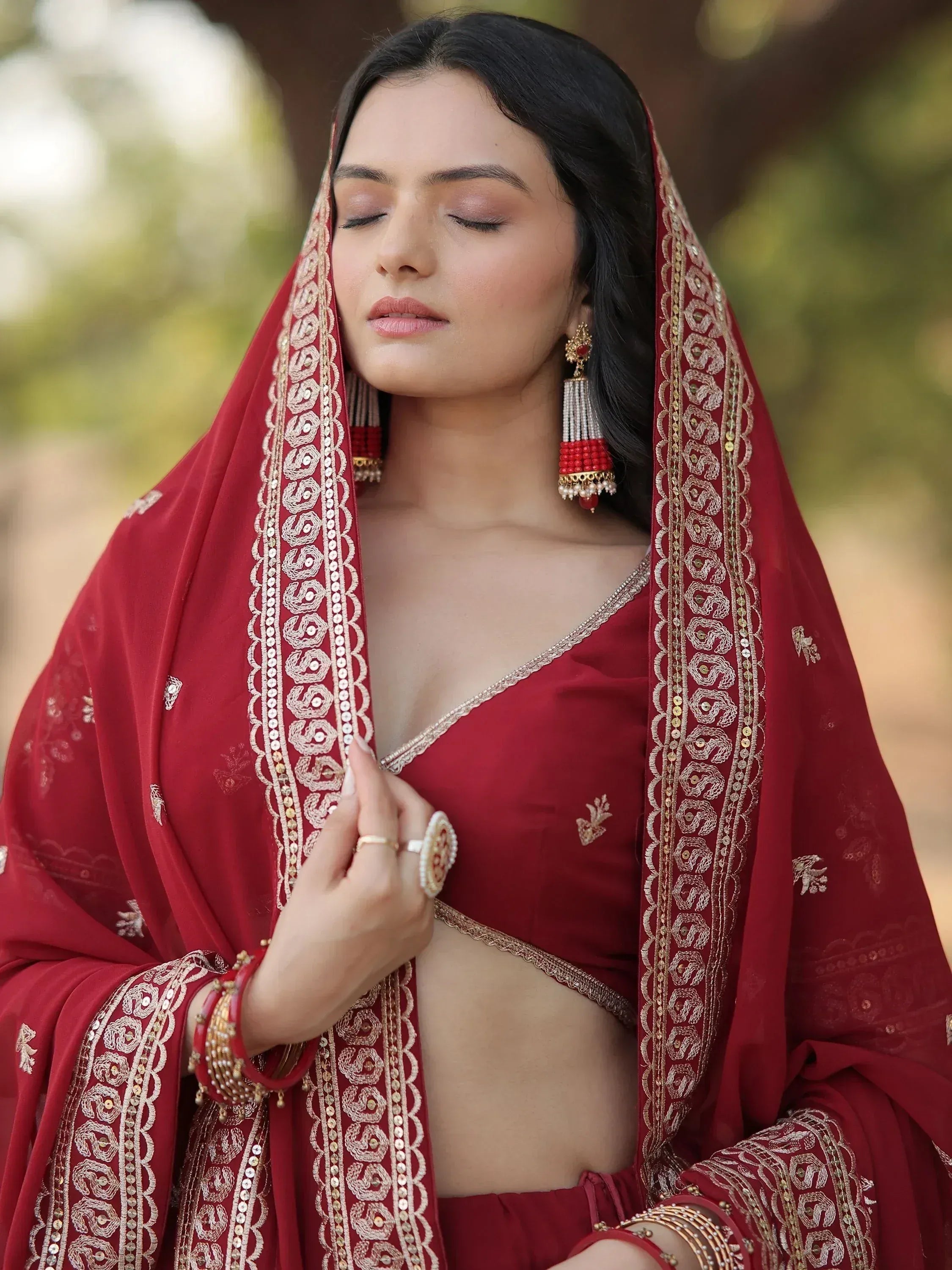 Elegant maroon ethnic lehenga choli with gold embroidery and matching dupatta, perfect for Indian weddings or festive occasions.