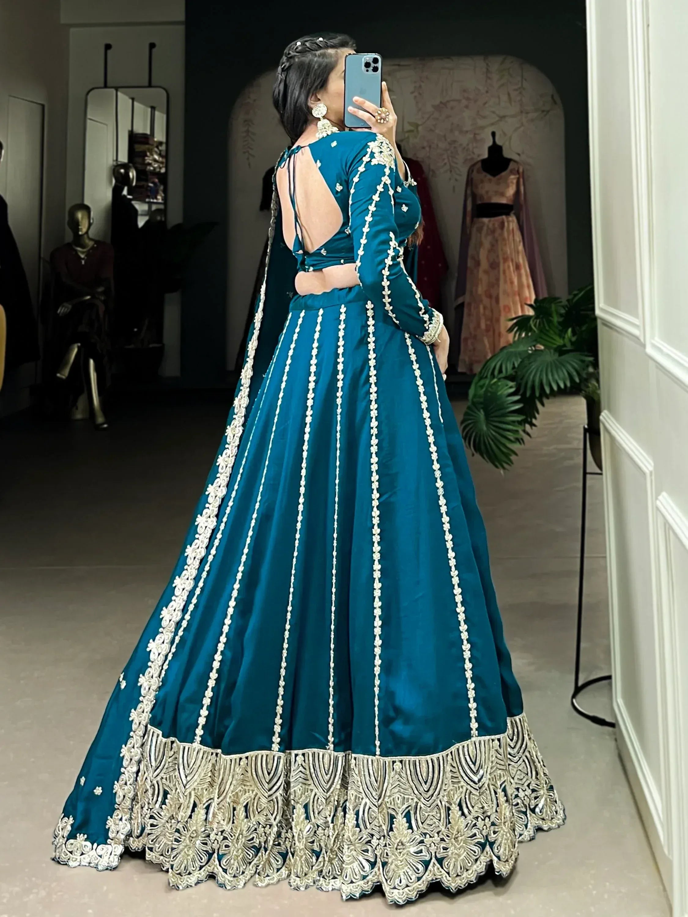 Teal designer lehenga choli with white floral embroidery, backless blouse, and heavy border detailing