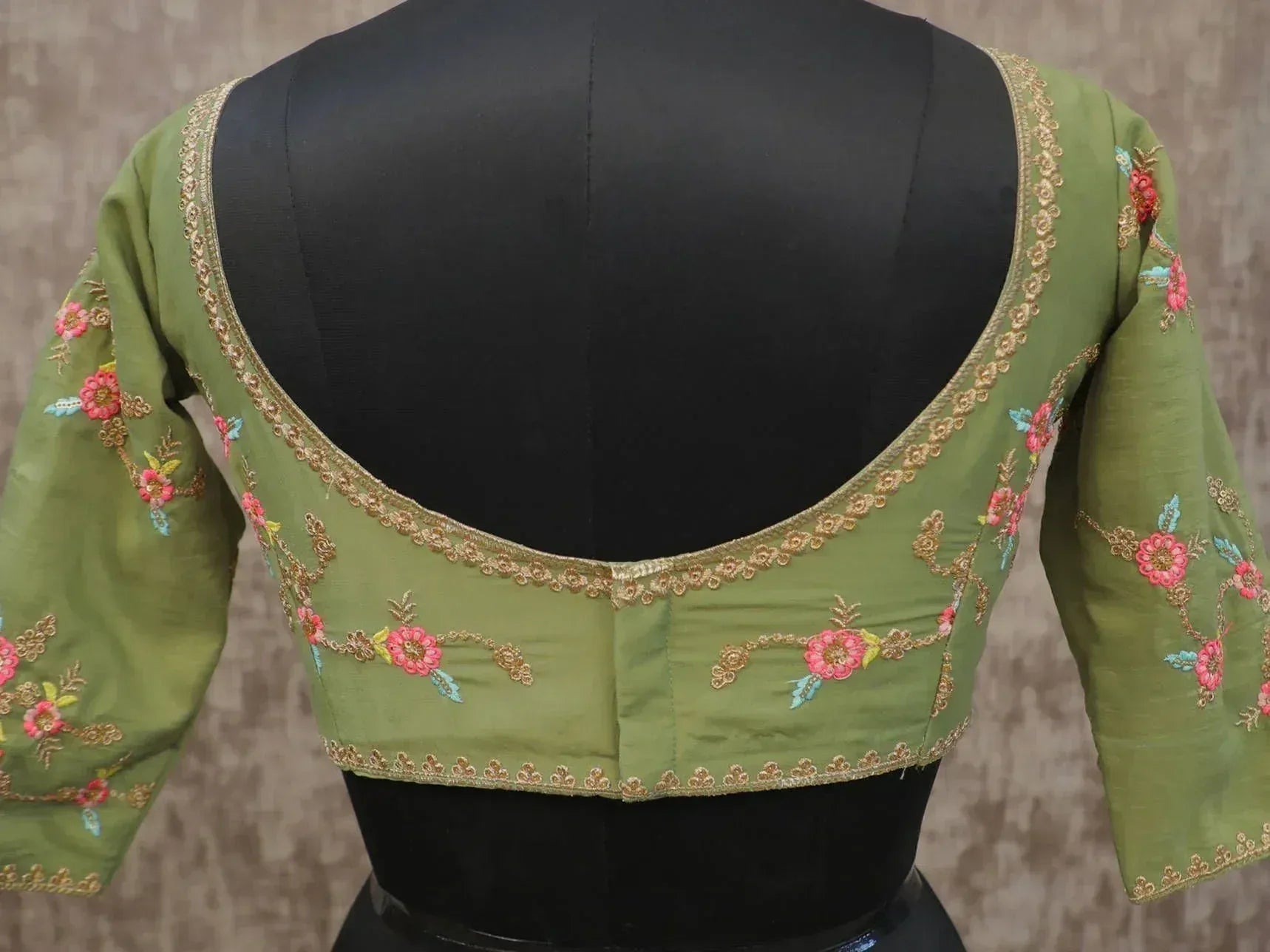 Olive green designer blouse with floral embroidery and gold trim, back view