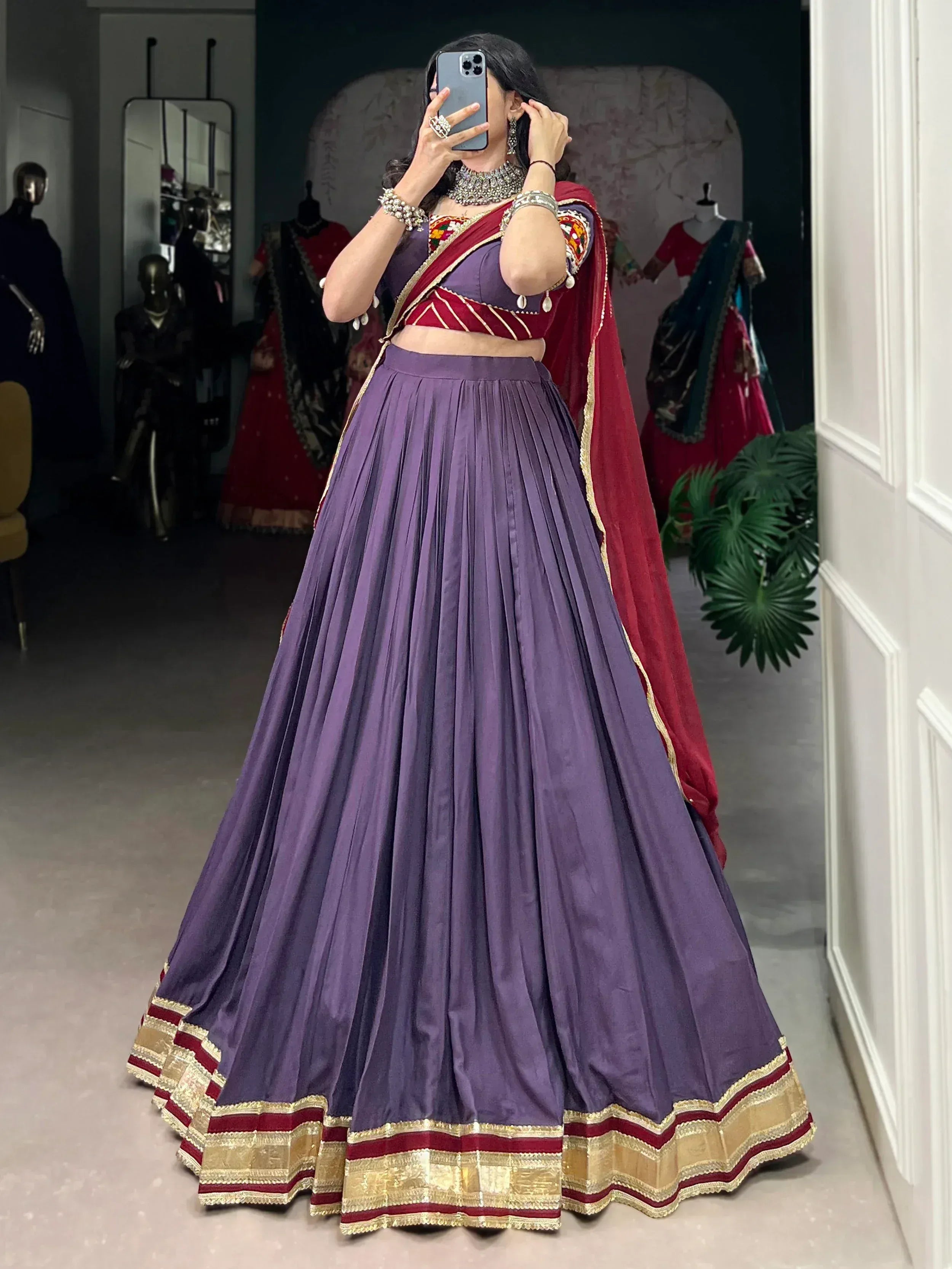 Purple lehenga choli with red dupatta, gold trim, and mirror work blouse for Indian ethnic wear