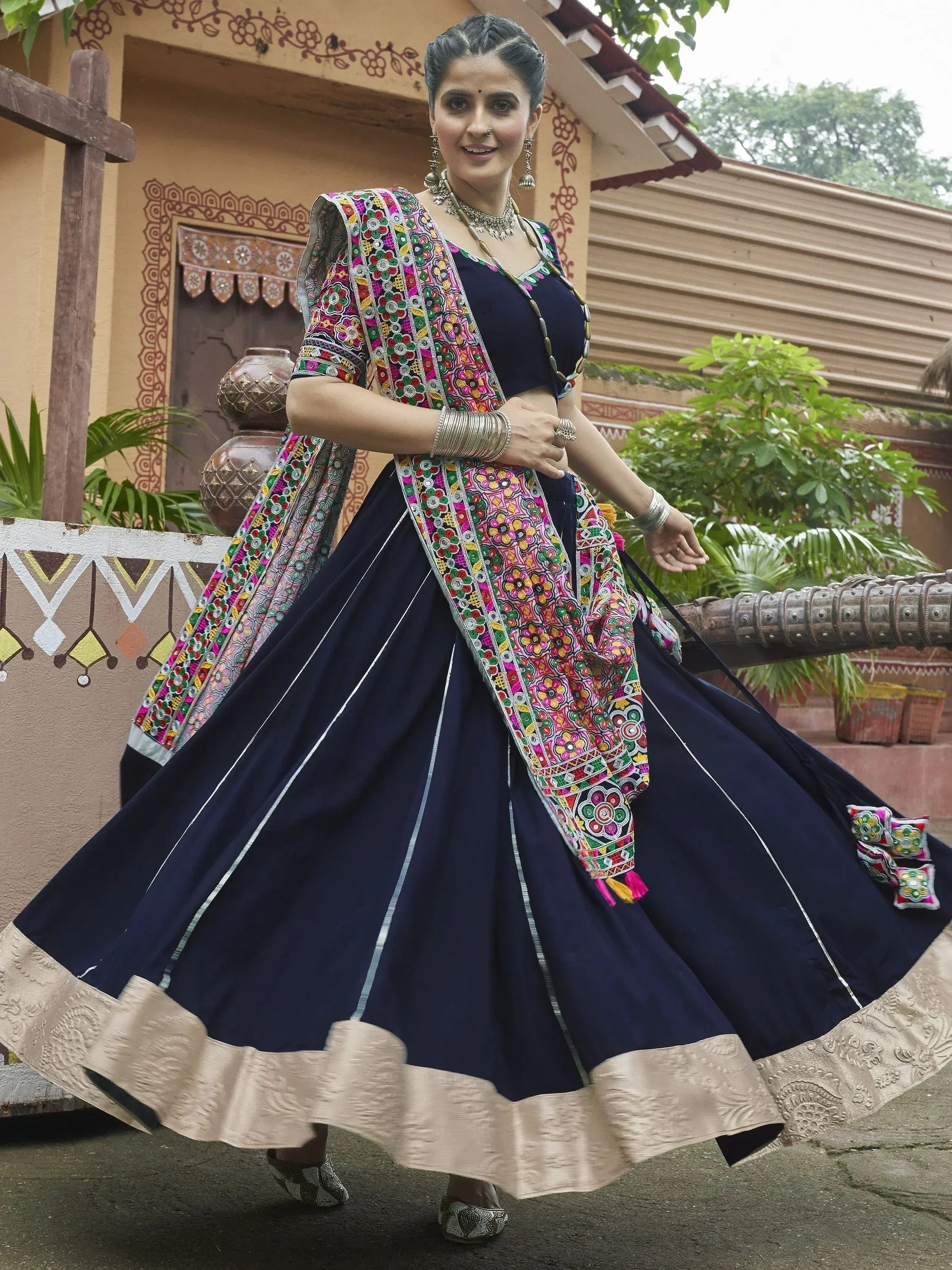 Navy blue lehenga choli with colorful floral embroidery and gold border, perfect for Indian ethnic wear