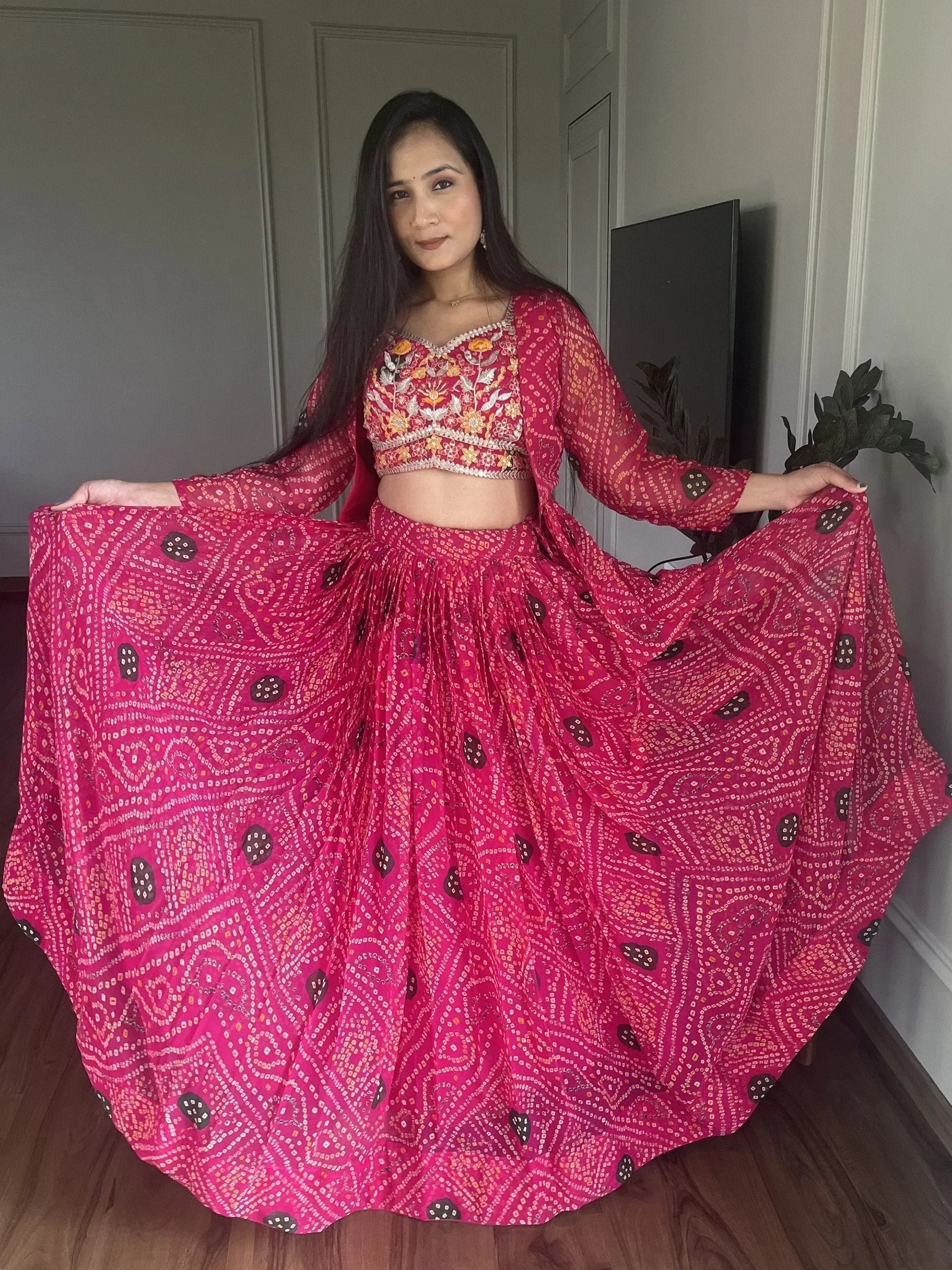 Woman in vibrant pink printed lehenga choli with floral embroidery, perfect for Indian ethnic occasions