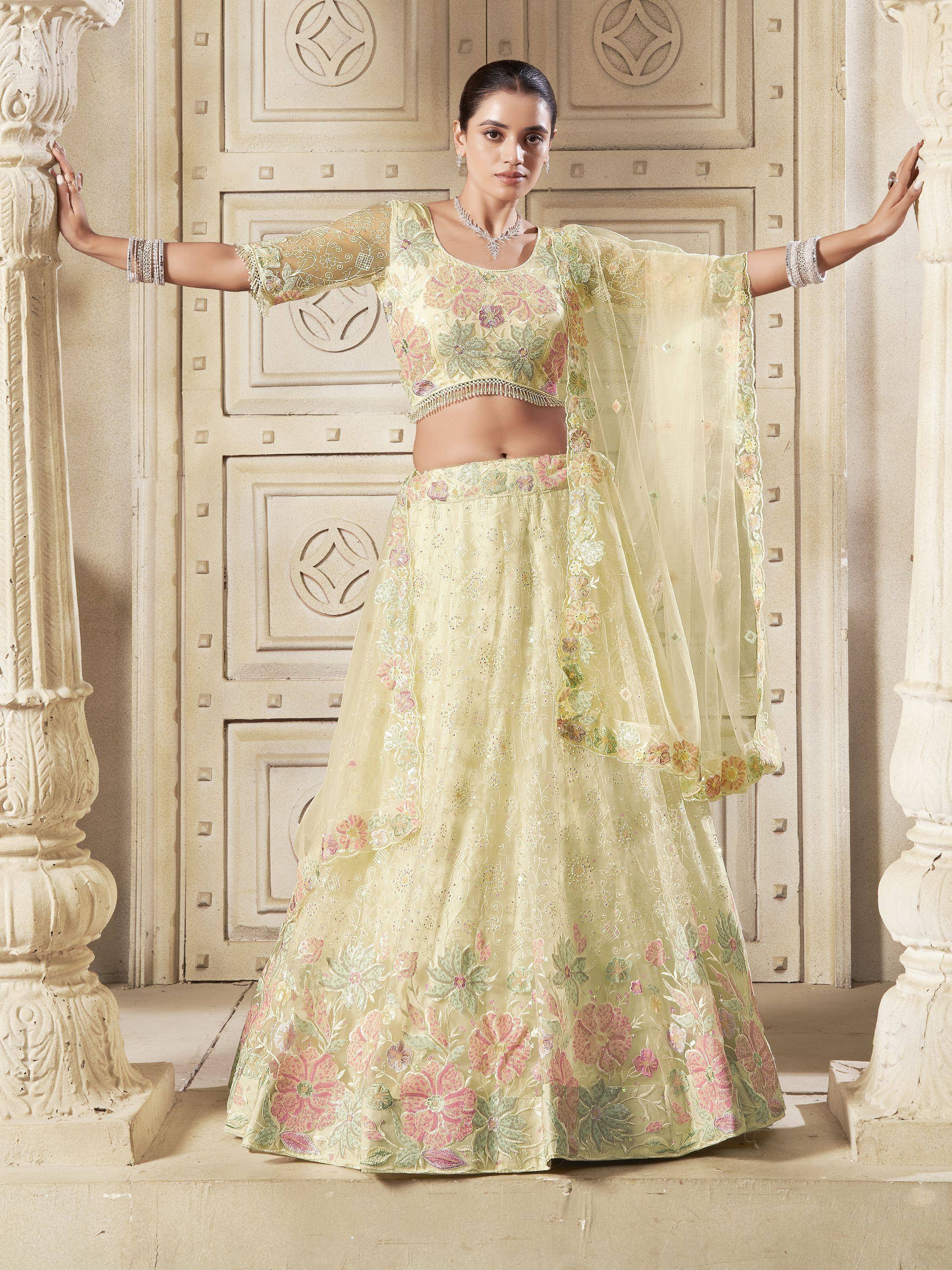 Elegant pastel yellow lehenga choli with floral embroidery, perfect for Indian weddings and festive occasions.