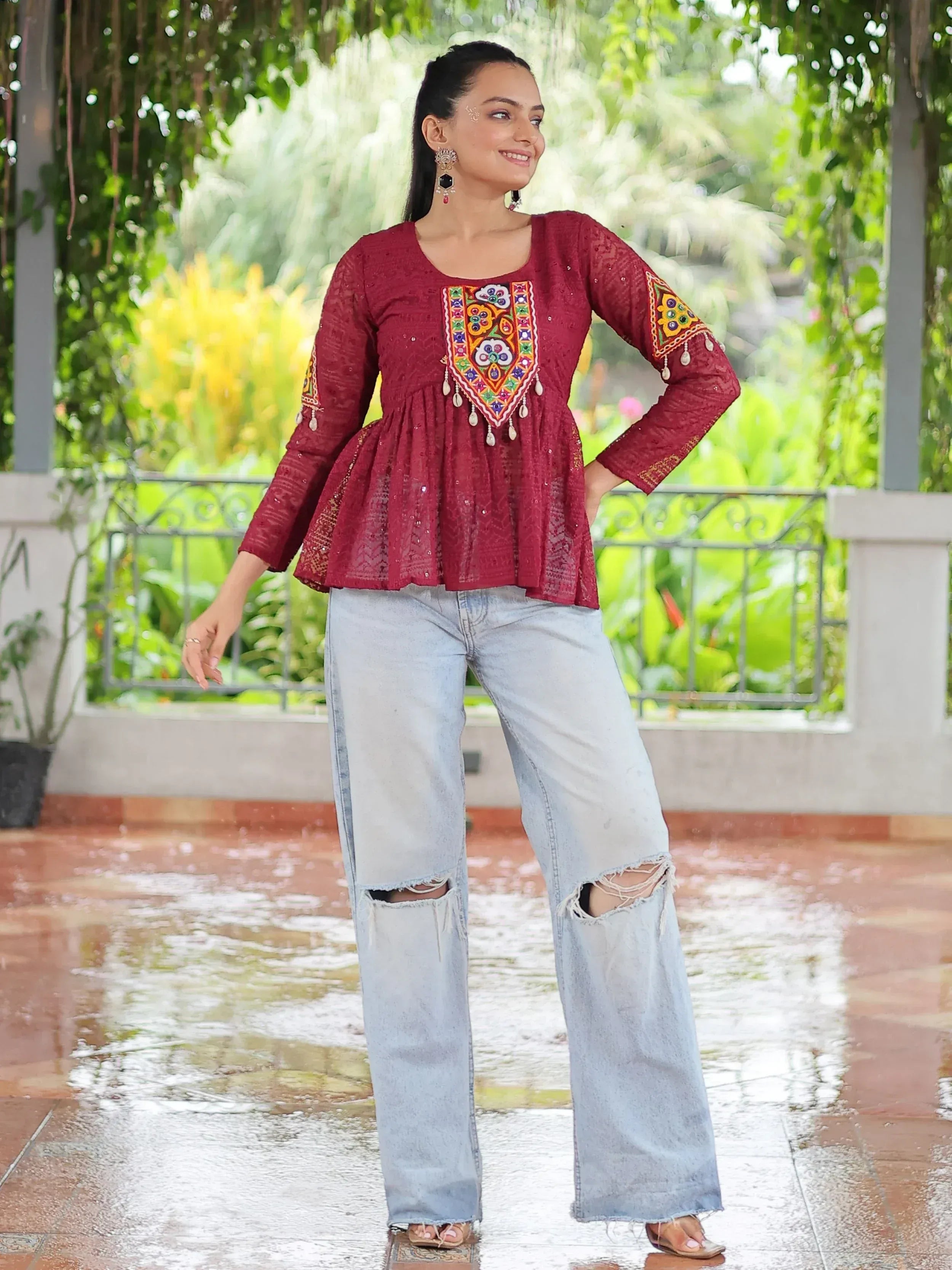 Maroon embroidered ethnic top with peplum hem paired with ripped jeans, perfect for fusion fashion.