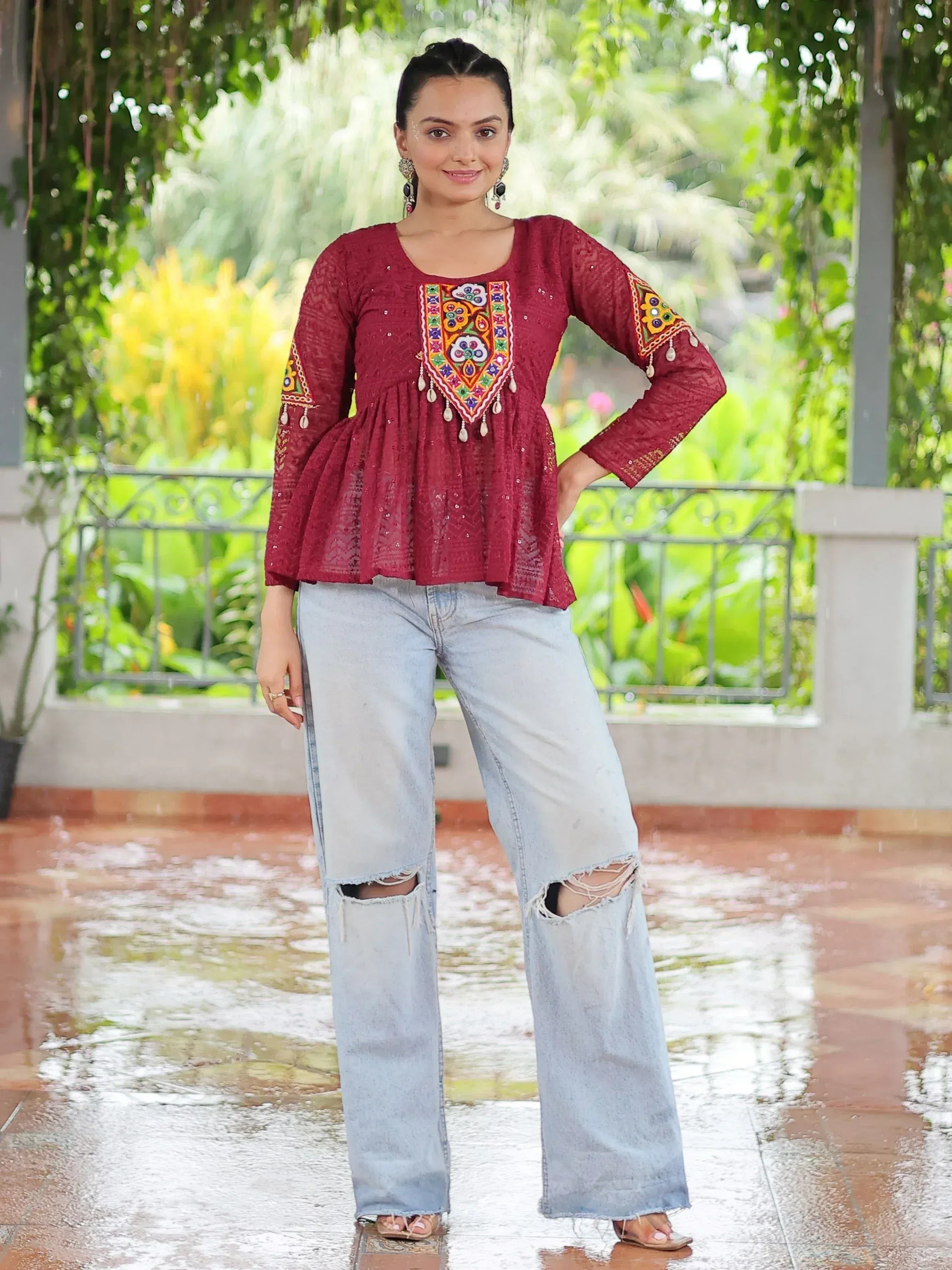 Maroon embroidered ethnic top with peplum hem paired with ripped jeans, perfect for casual Indian wear.