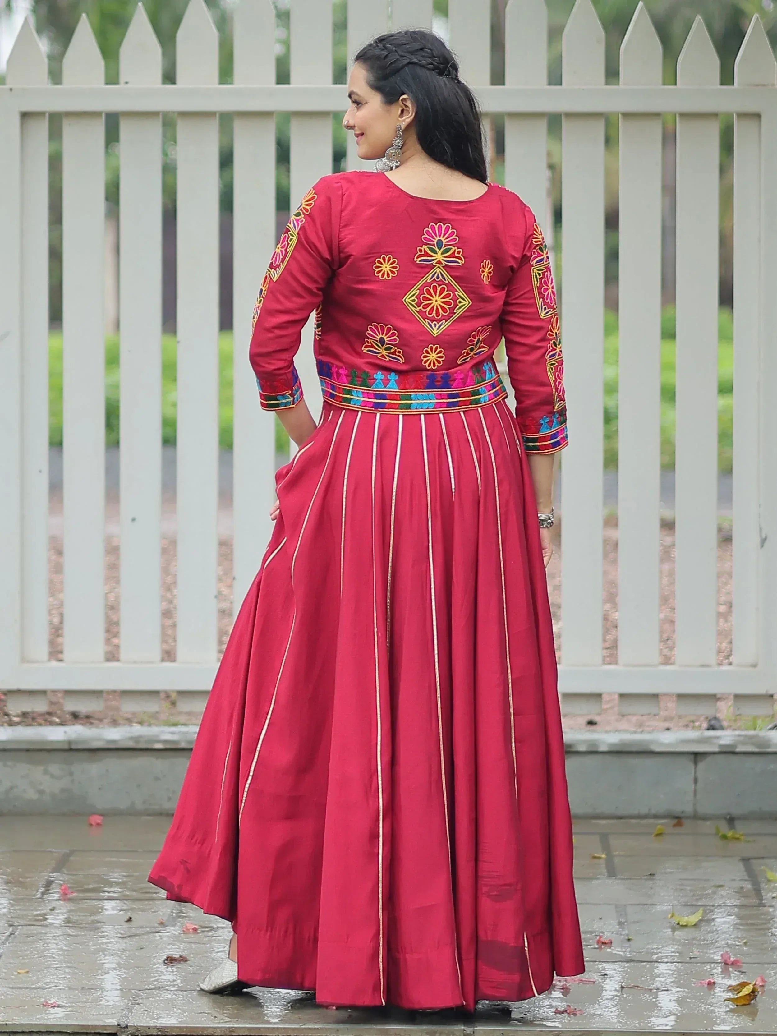 Red embroidered ethnic gown with floral motifs and pleated skirt, perfect for Indian occasions