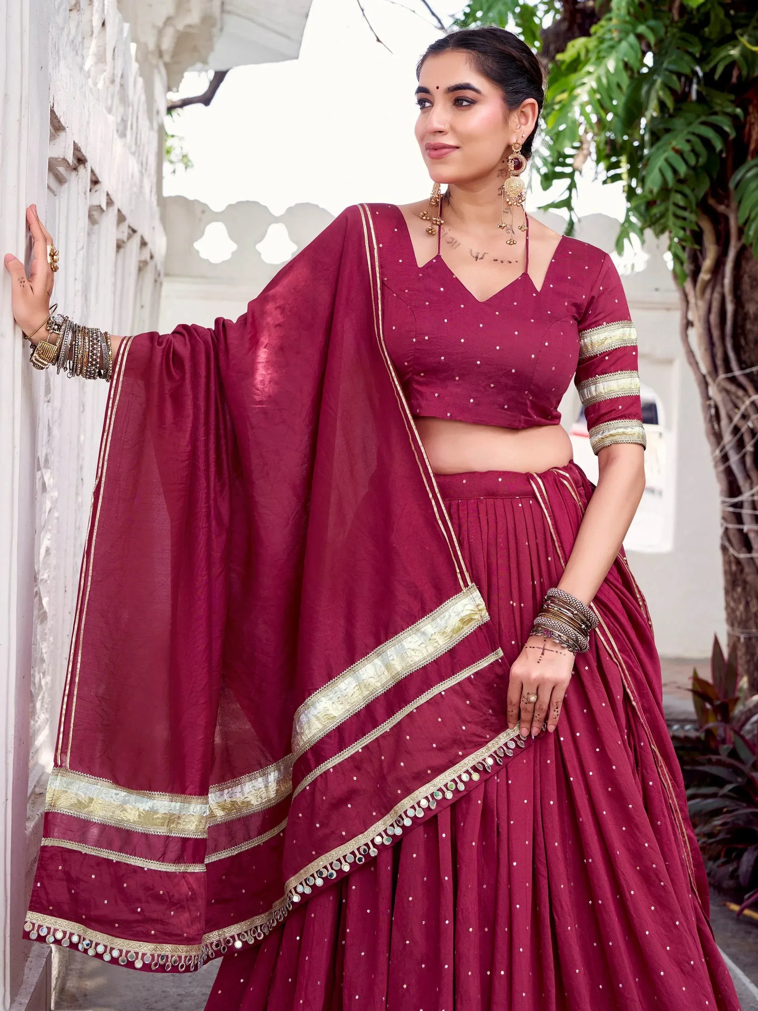 Maroon designer lehenga choli with gold trim and mirror work, perfect for Indian ethnic wear occasions