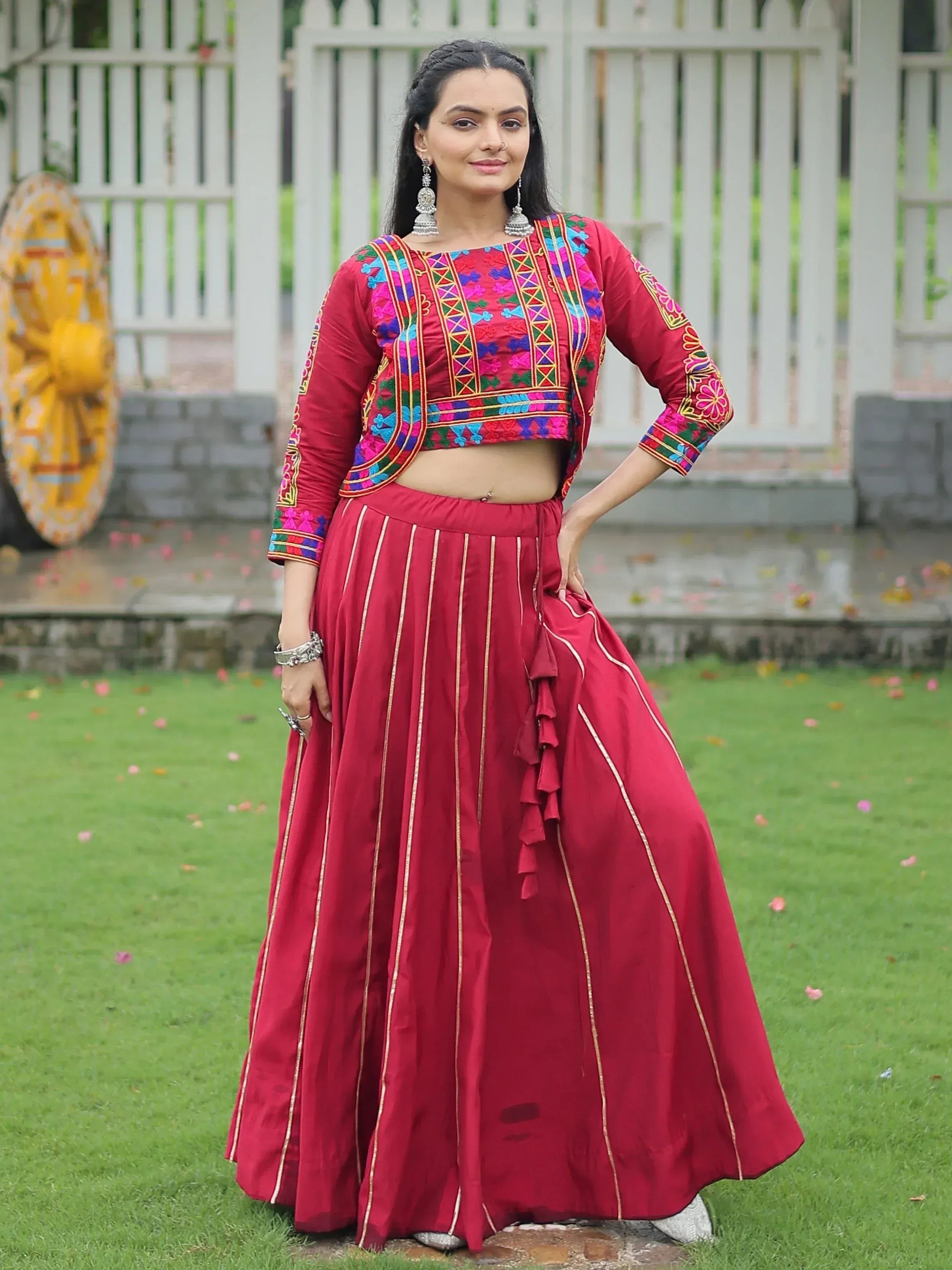Red embroidered lehenga choli with floral patterns and gold stripes, perfect for Indian ethnic wear.