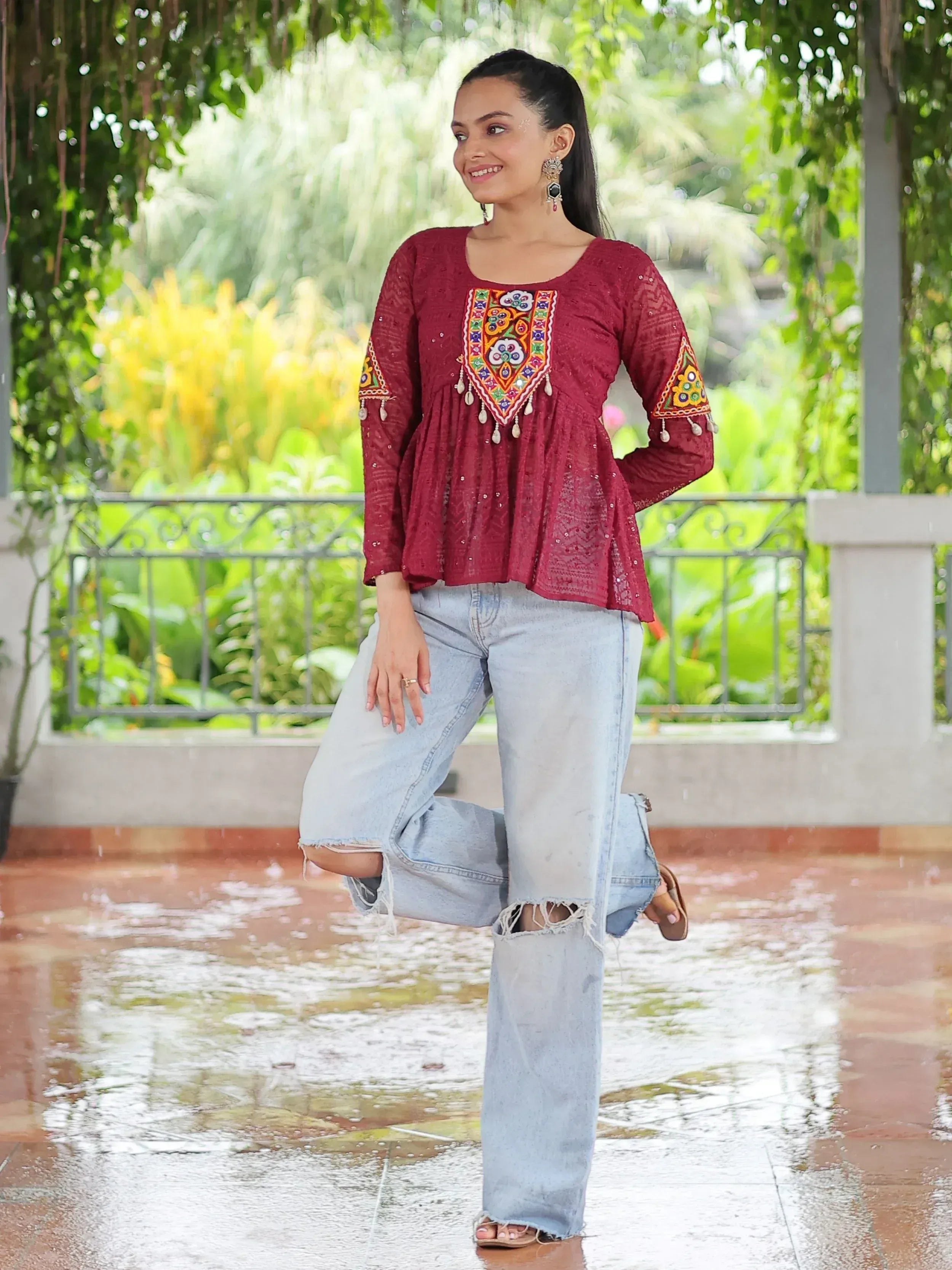 Maroon embroidered ethnic top with mirror work, paired with ripped jeans, perfect for casual Indian wear