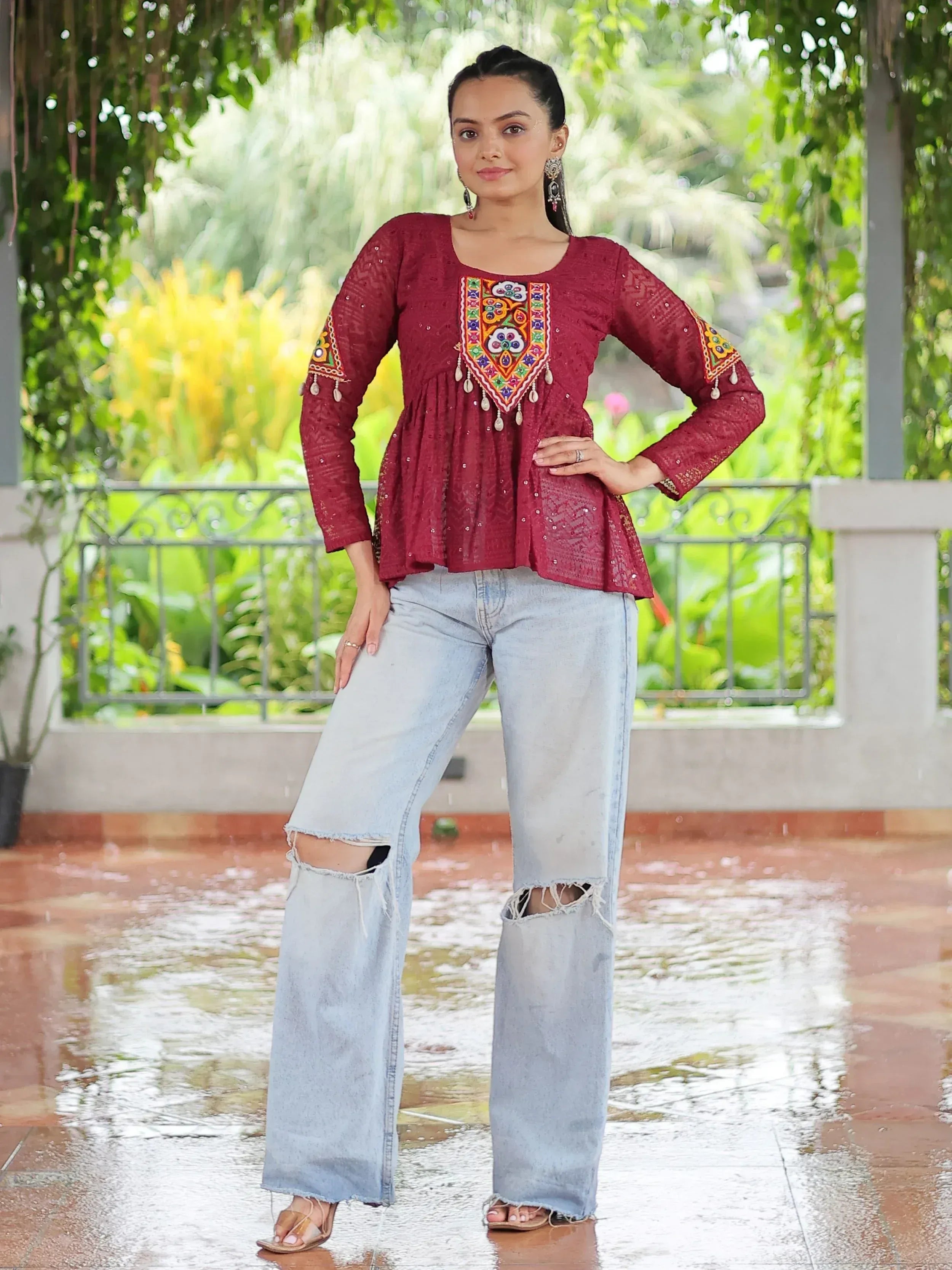 Maroon embroidered ethnic top with mirror work, paired with ripped wide-leg jeans, perfect for casual Indian wear.