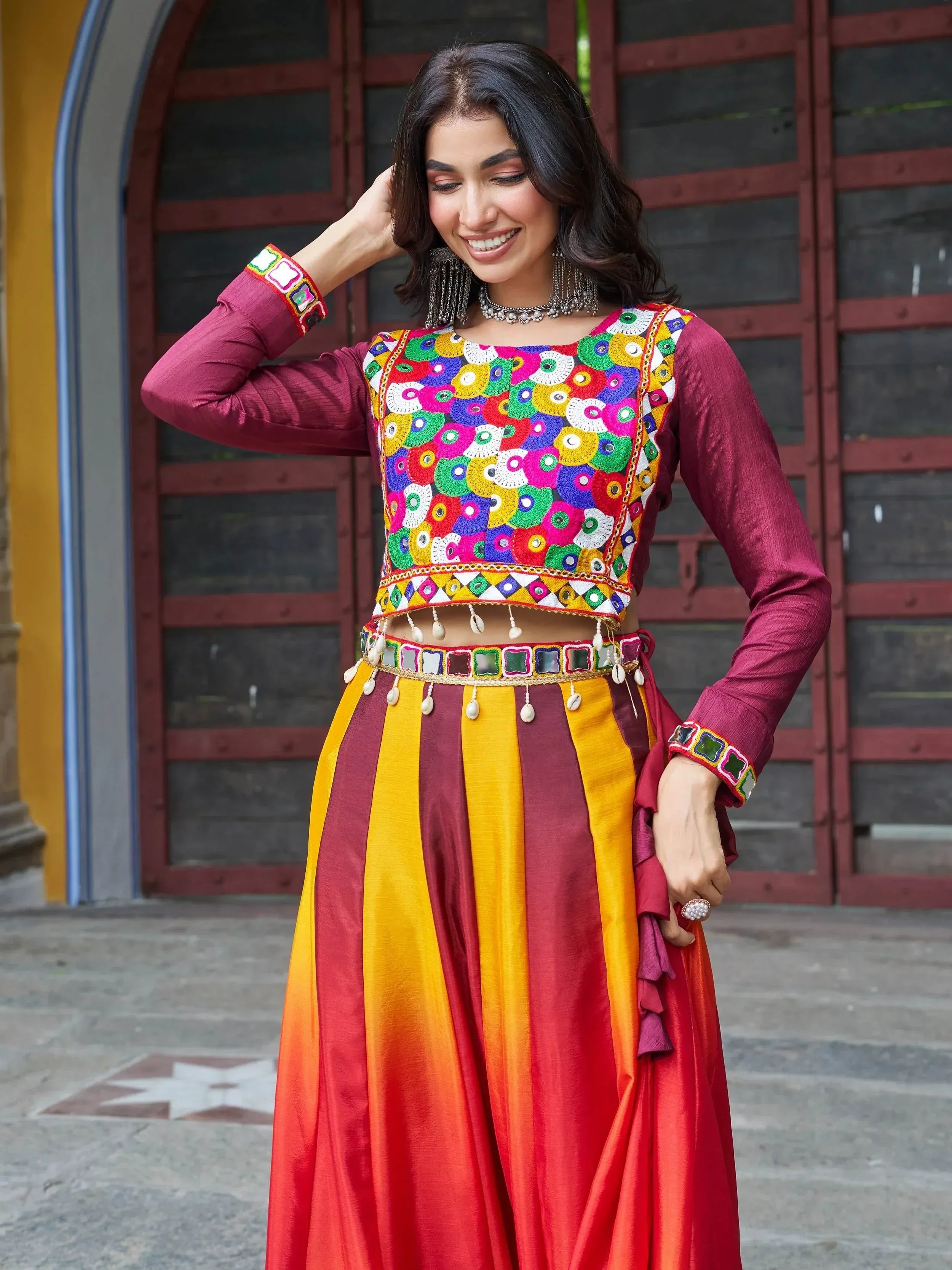 Colorful Indian ethnic wear with mirror work blouse and striped skirt, perfect for festive occasions.