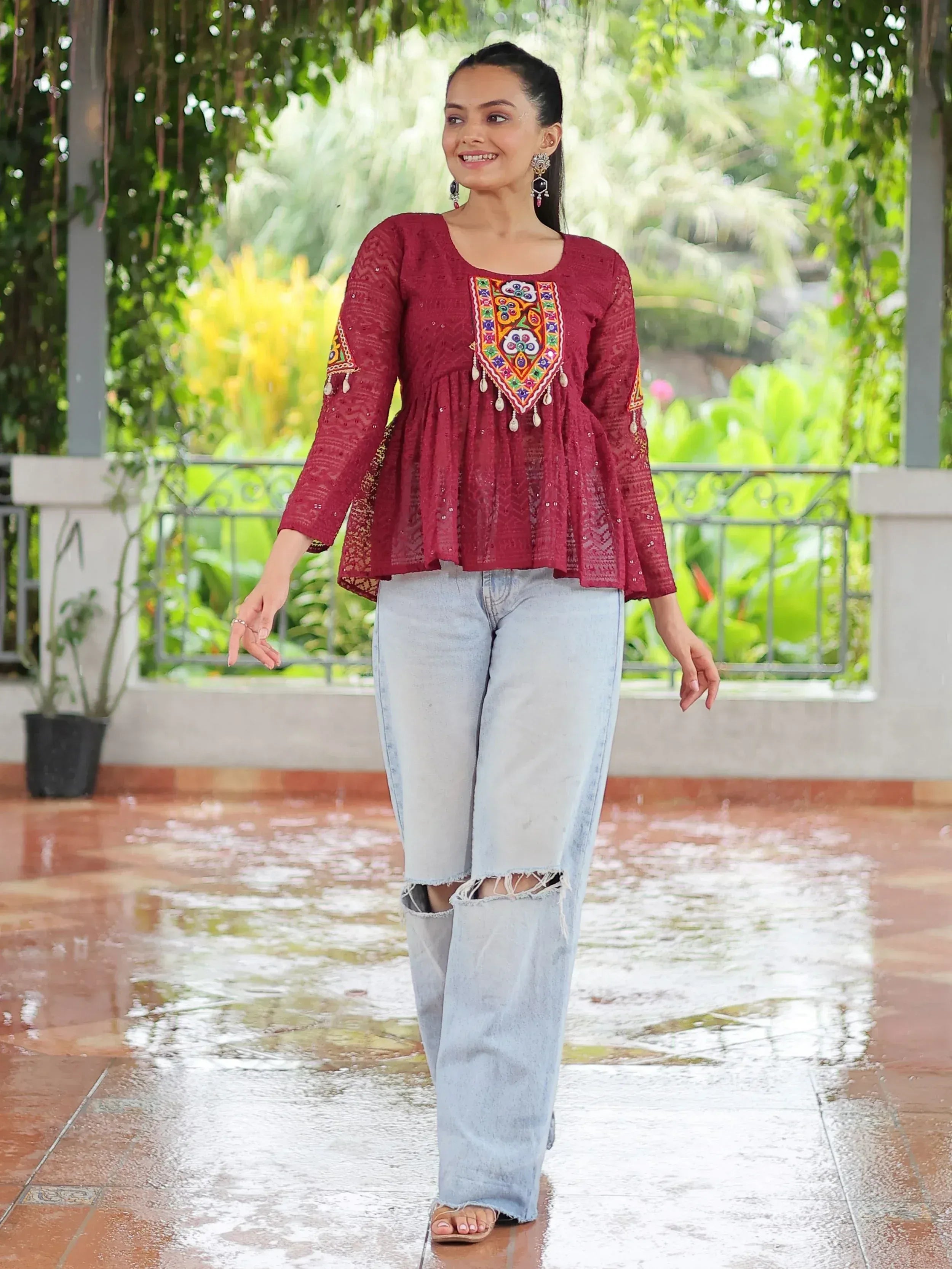 Maroon embroidered ethnic top with bell sleeves paired with ripped jeans, perfect for casual Indian wear