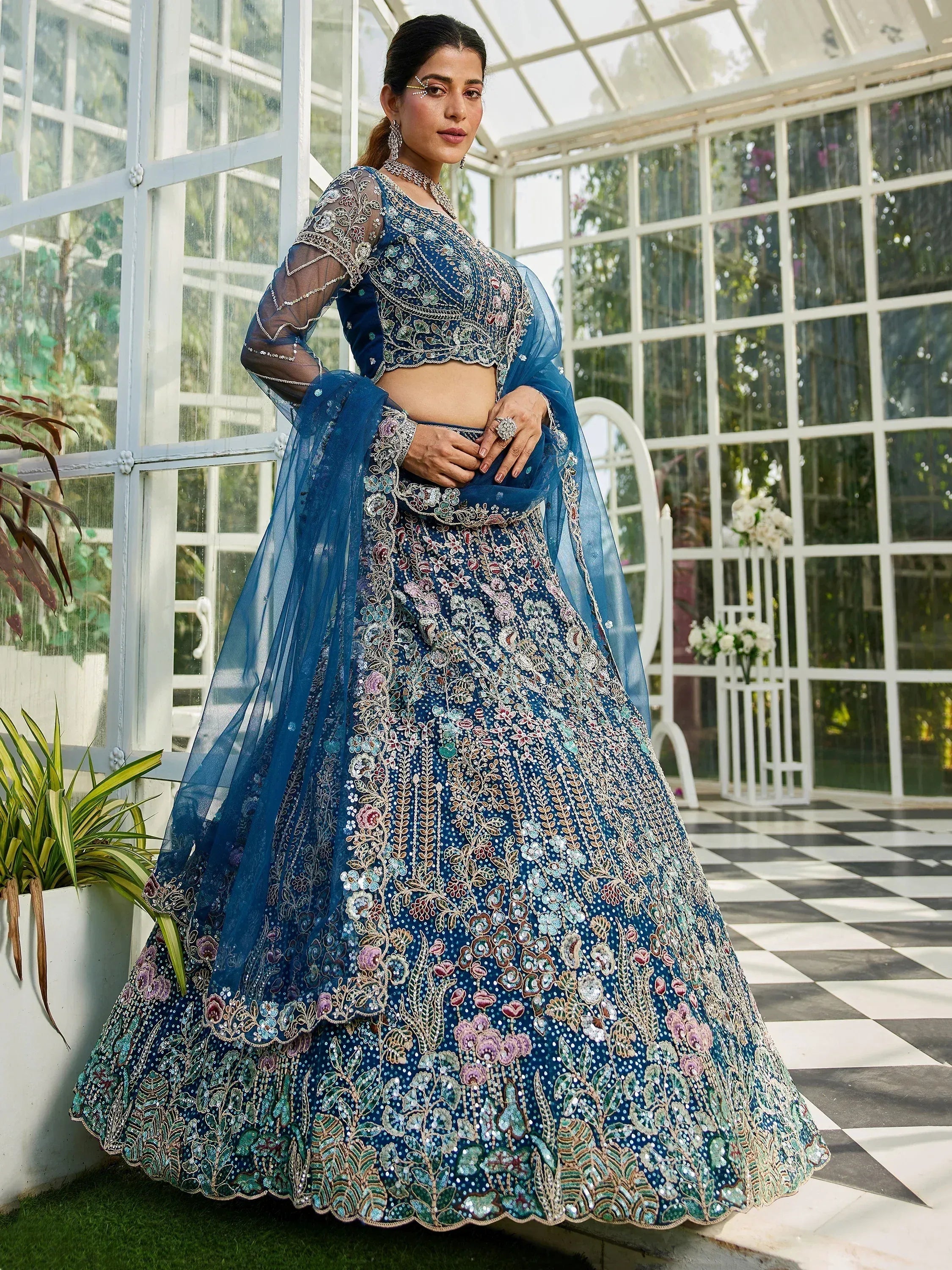 Blue floral embroidered lehenga choli with sheer sleeves, perfect for Indian weddings and festive occasions.