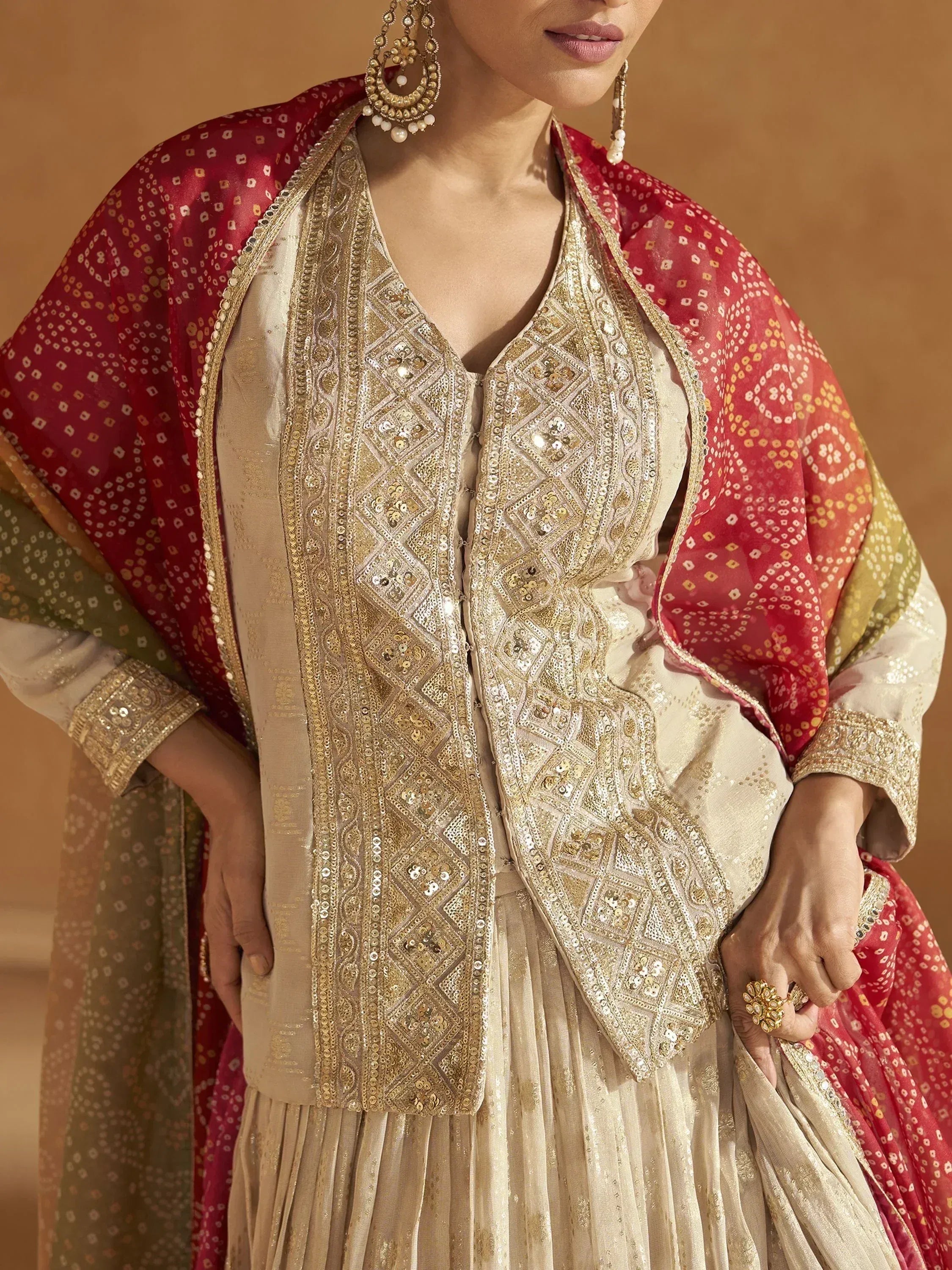 Elegant Indian ethnic wear with gold embroidery, sequins, and red dupatta for festive occasions