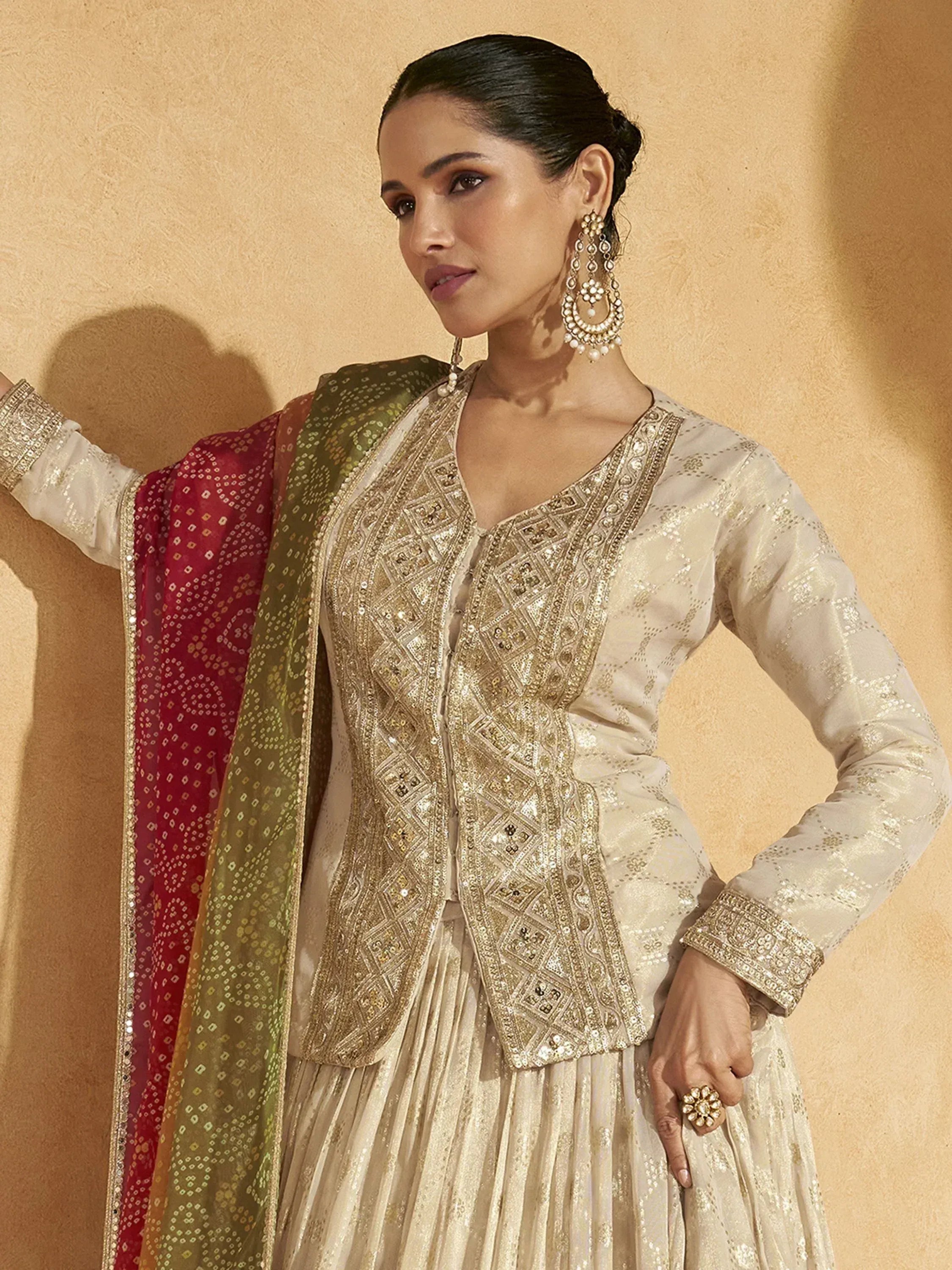 Elegant ivory ethnic wear with gold embroidery, paired with red and green dupatta, perfect for Indian occasions.