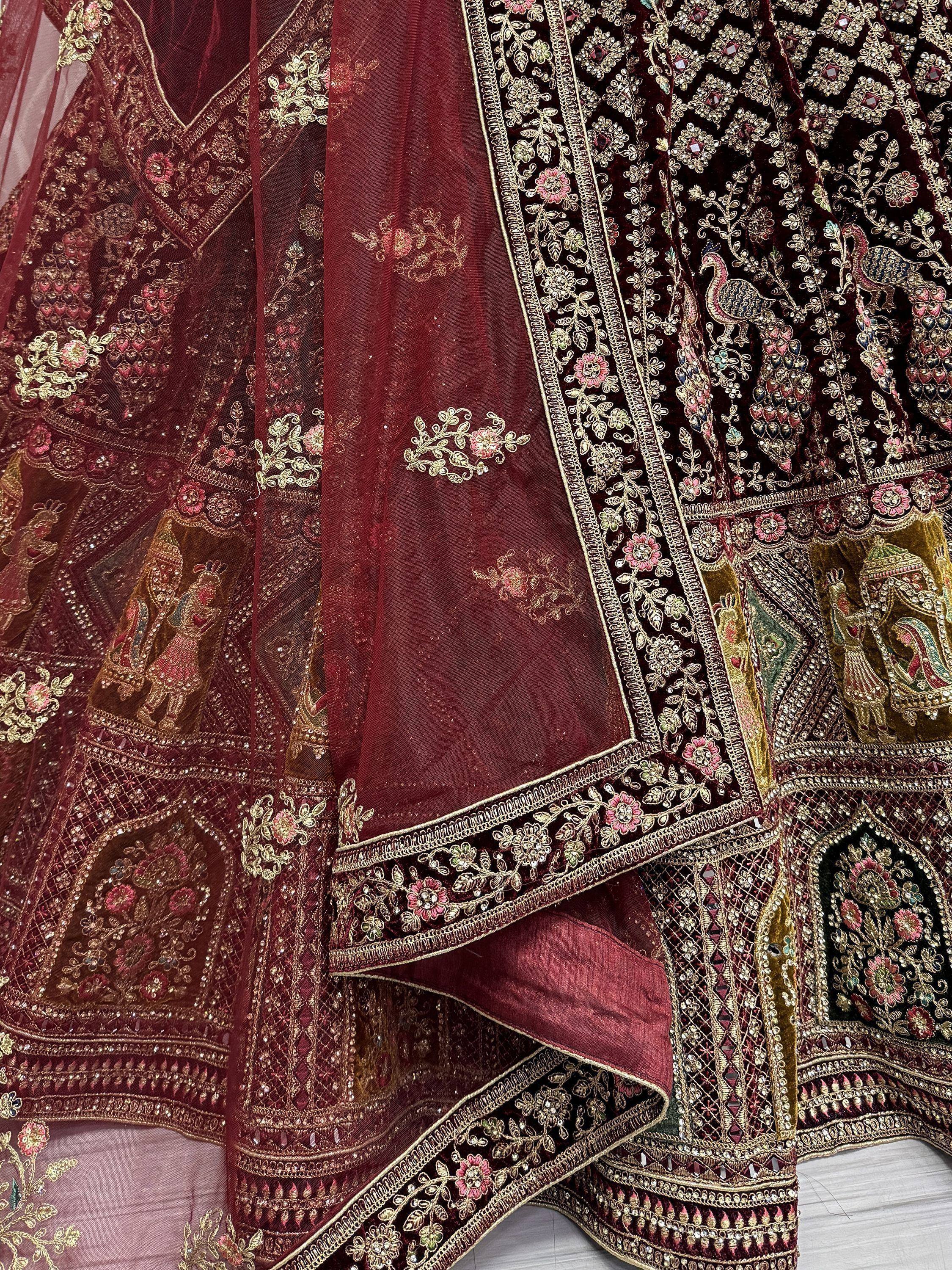 Luxury maroon lehenga choli with heavy gold embroidery, floral motifs, and peacock designs for Indian weddings.
