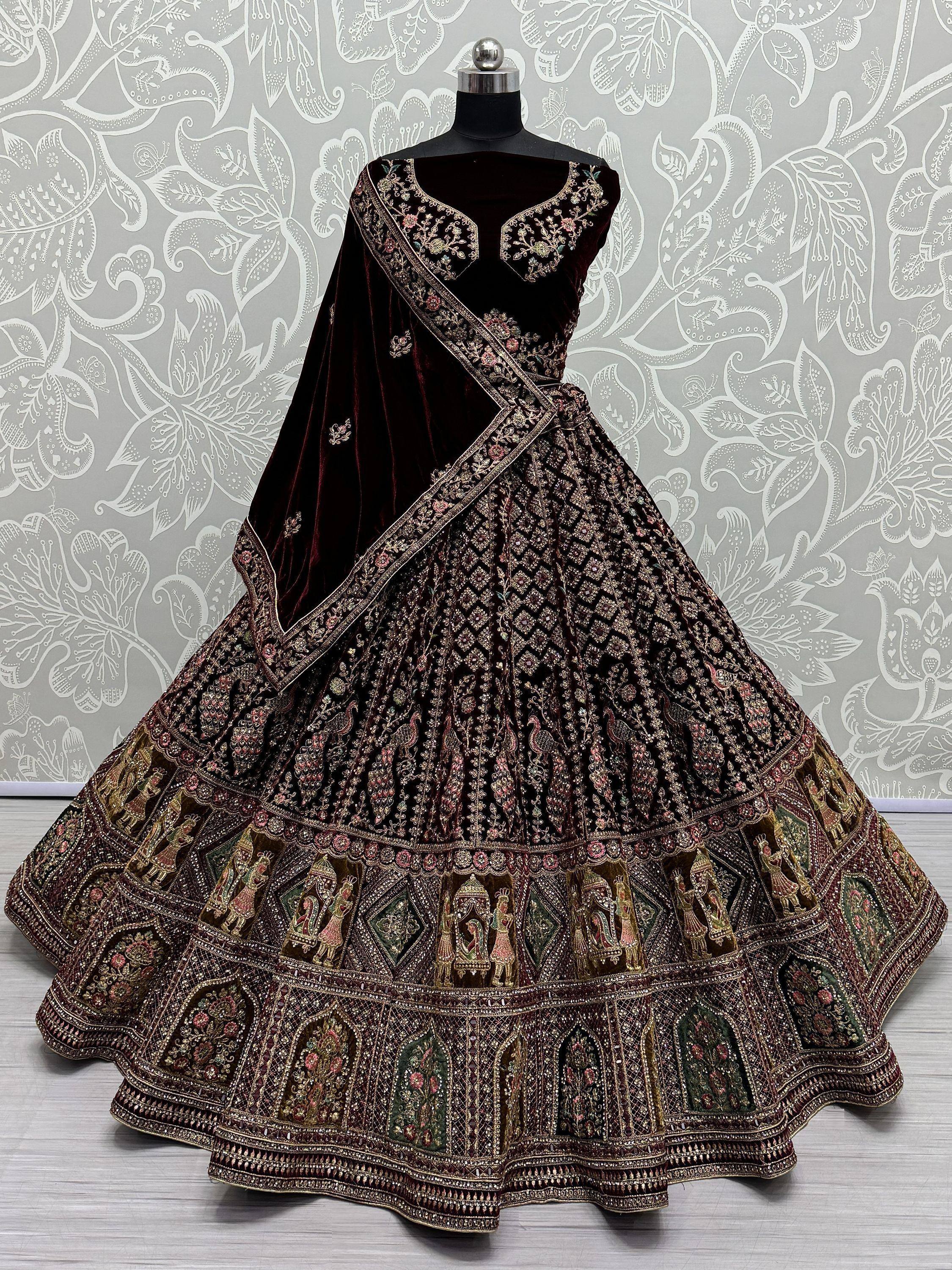 Designer maroon velvet lehenga choli with heavy embroidery and traditional motifs, perfect for Indian weddings.