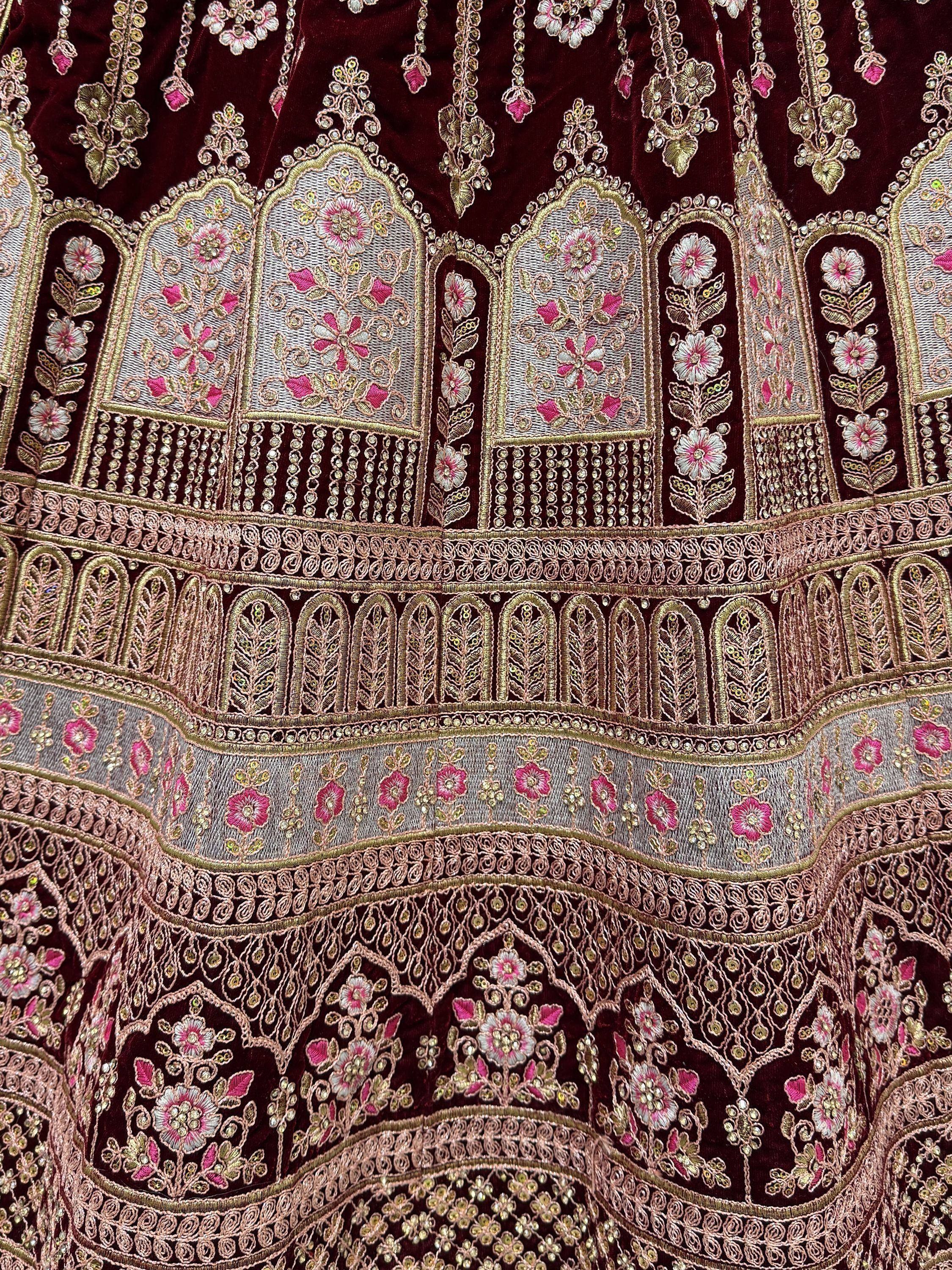 Luxury maroon velvet lehenga with intricate gold and pink floral embroidery and beadwork