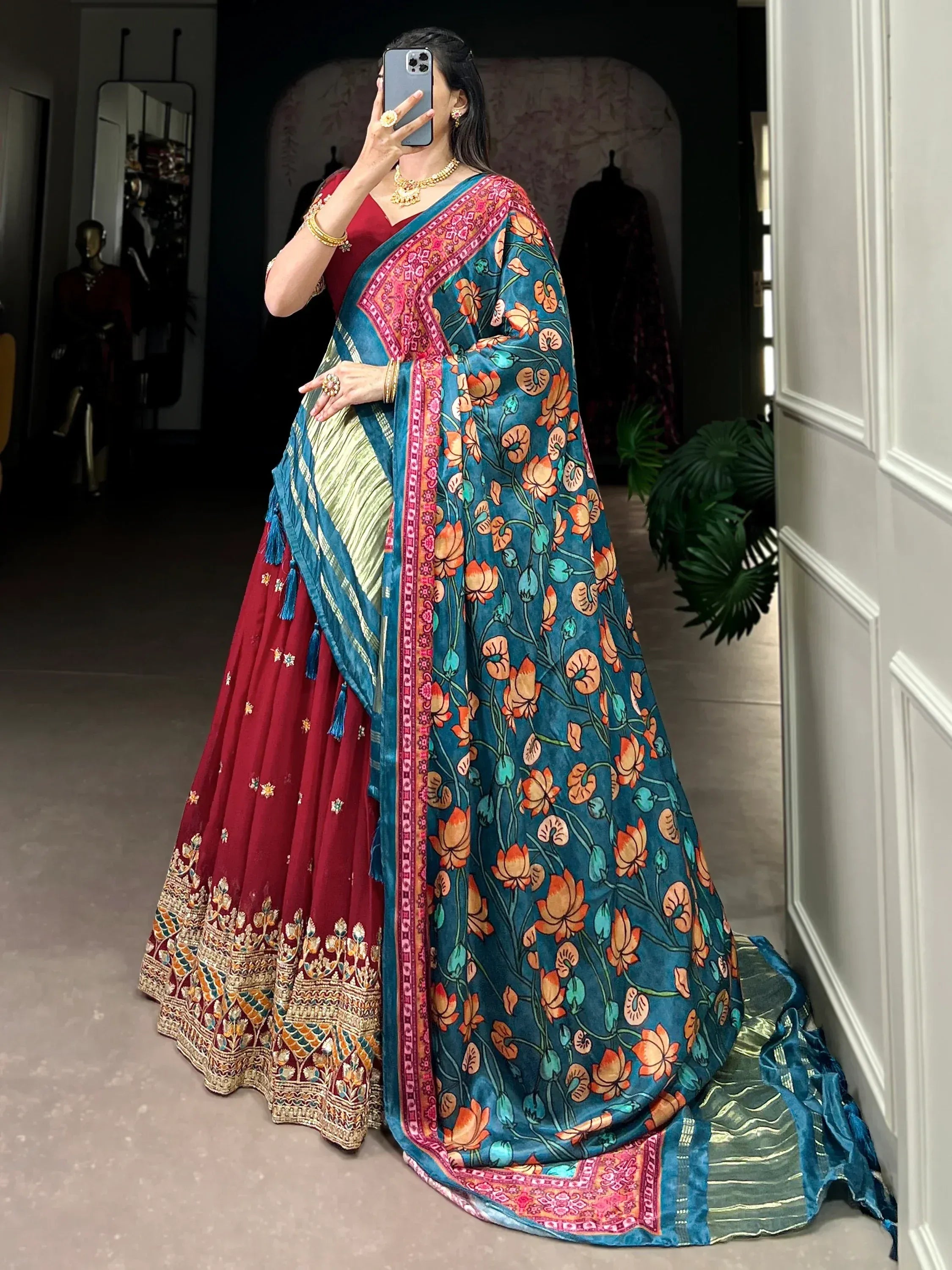 Woman in maroon lehenga with floral blue dupatta, ethnic Indian wear for festive occasions