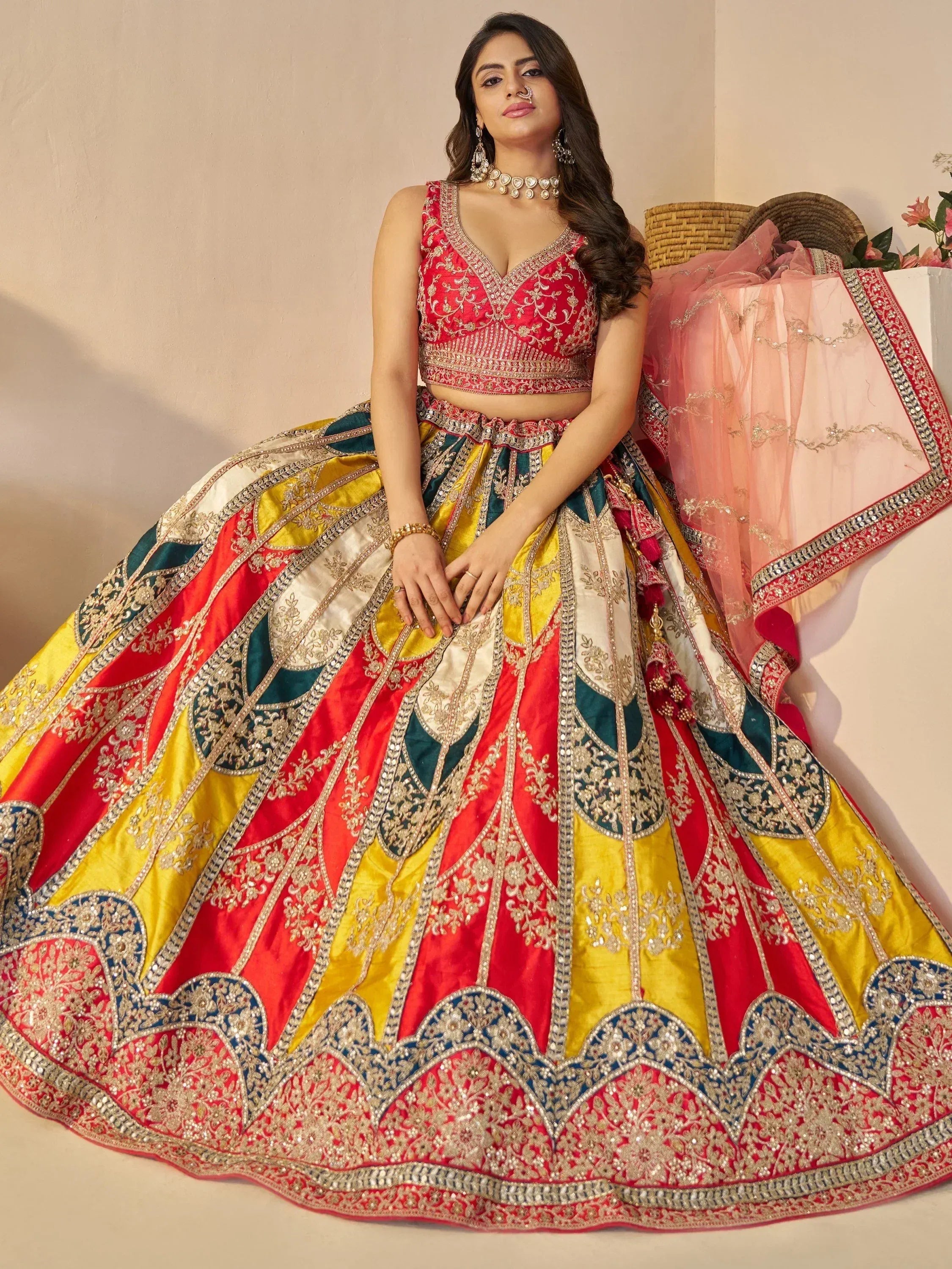 Designer lehenga choli with vibrant red, yellow, and green panels, heavy embroidery, and matching dupatta for Indian ethnic wear