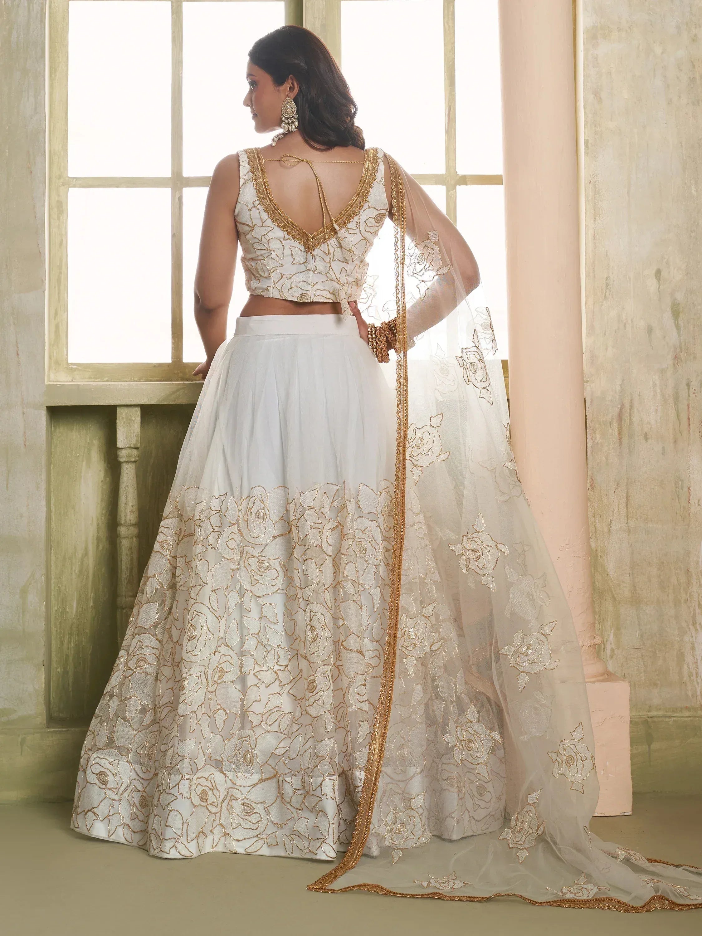 White and gold embroidered lehenga choli with floral design and sheer dupatta, perfect for Indian ethnic wear.
