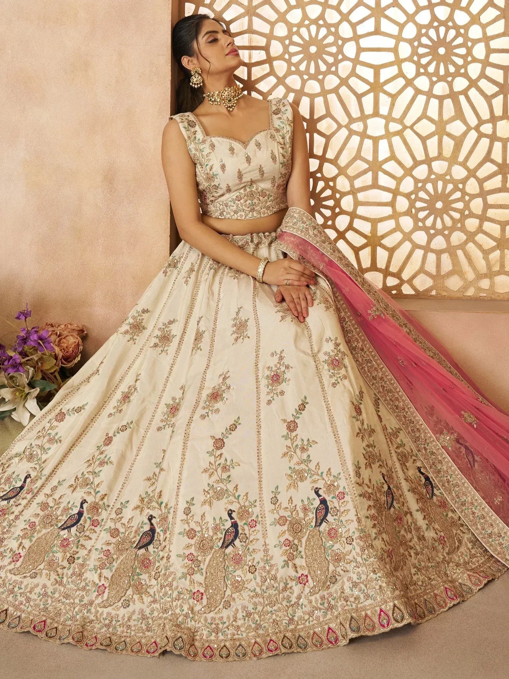 Cream embroidered lehenga choli with peacock motifs, pink dupatta, perfect for Indian weddings and festive occasions.