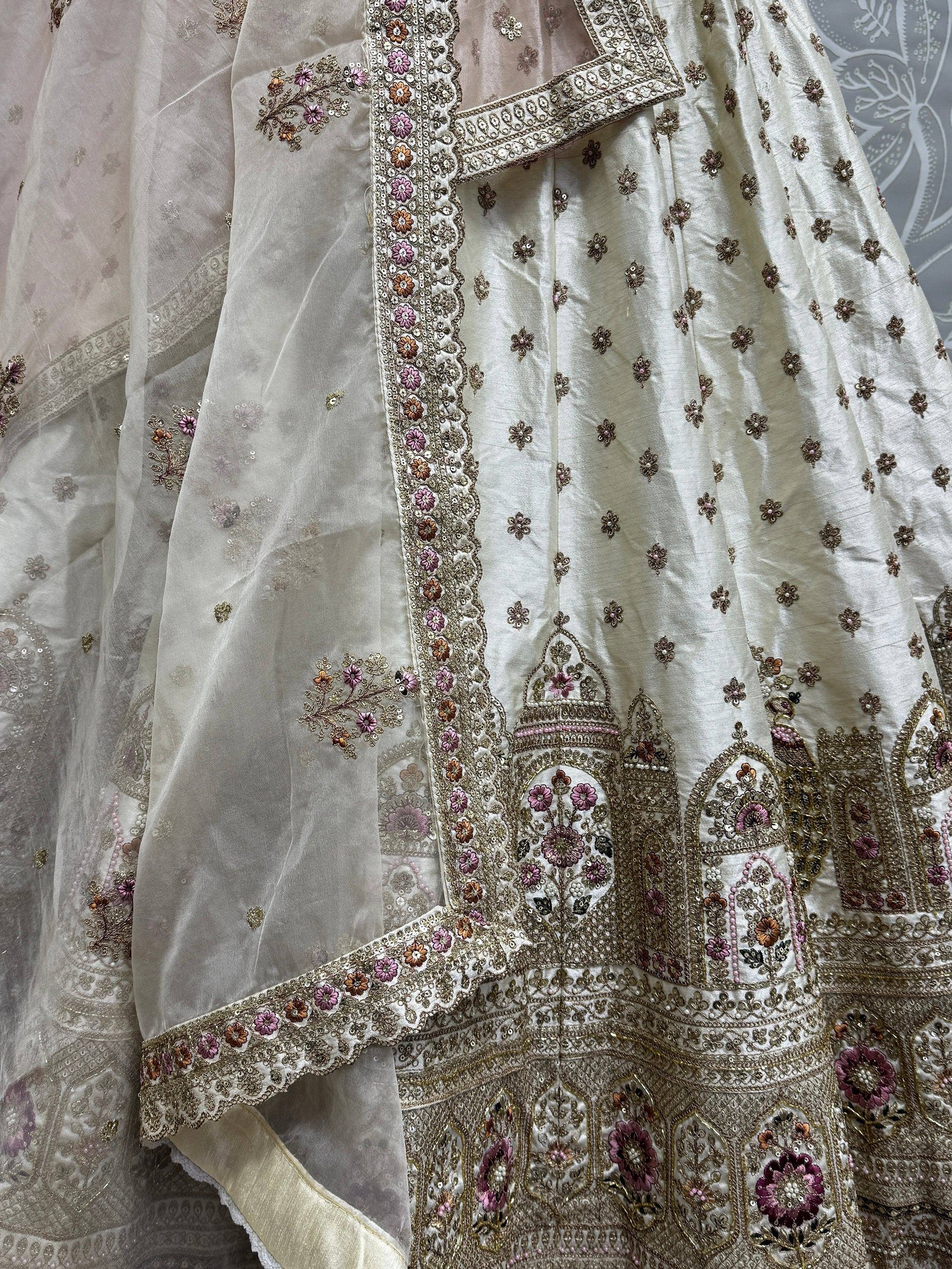 Elegant white lehenga choli with intricate floral embroidery and gold detailing, perfect for Indian ethnic wear.