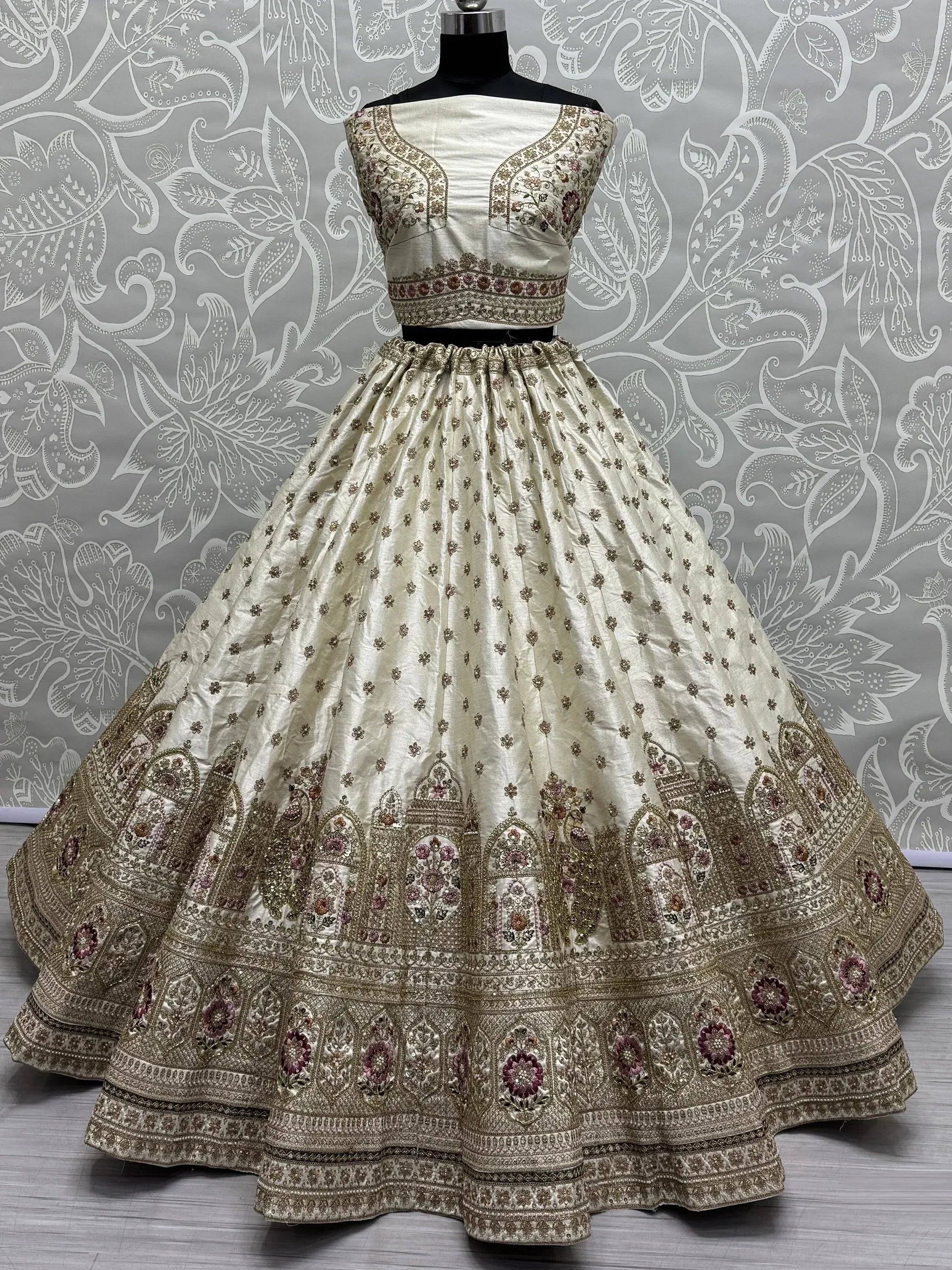 Cream embroidered lehenga choli with floral motifs and heavy border, perfect for Indian weddings and festive occasions.