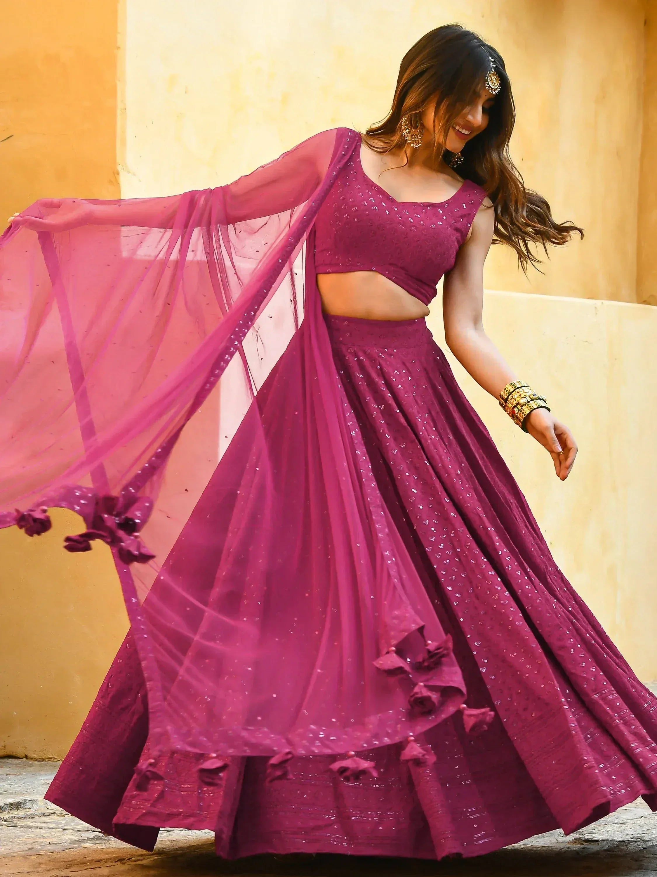 Woman in vibrant purple sequined lehenga choli with flowing dupatta, perfect for Indian ethnic occasions