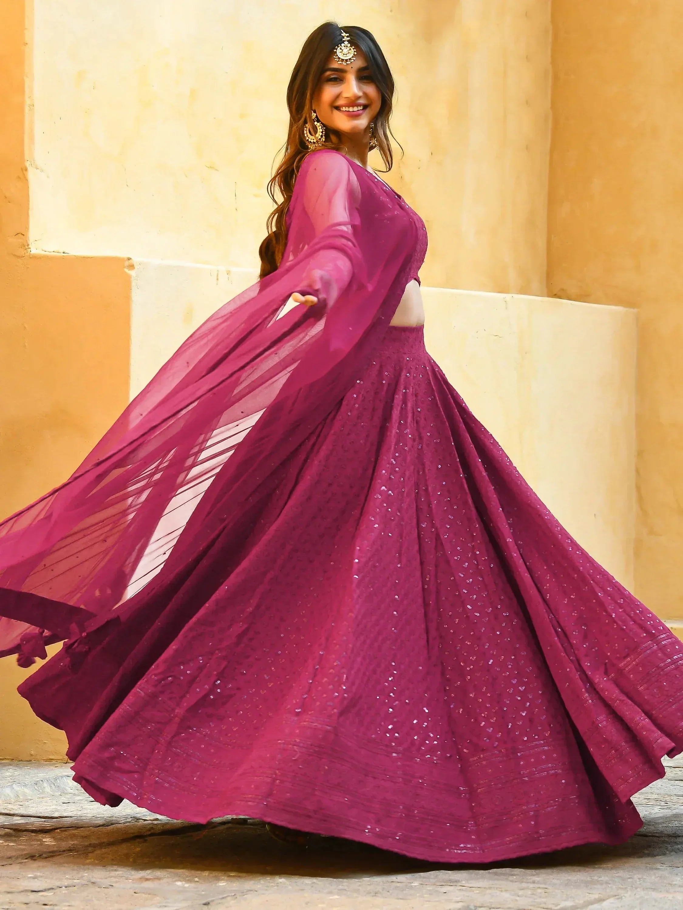 Woman in elegant purple lehenga choli with sheer dupatta, perfect for Indian ethnic occasions