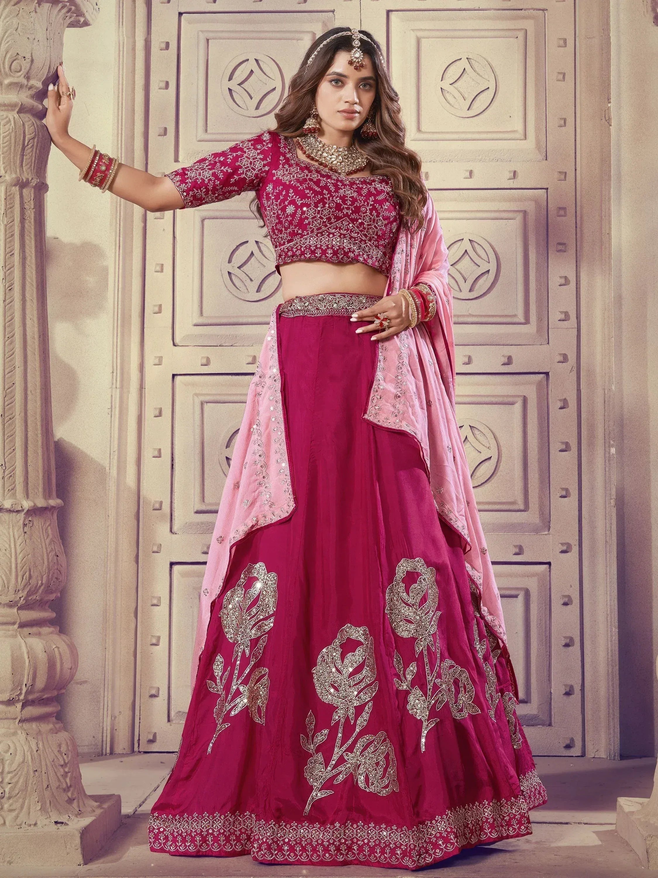 Elegant maroon lehenga choli with gold floral embroidery and pink dupatta, perfect for Indian weddings and festive occasions.